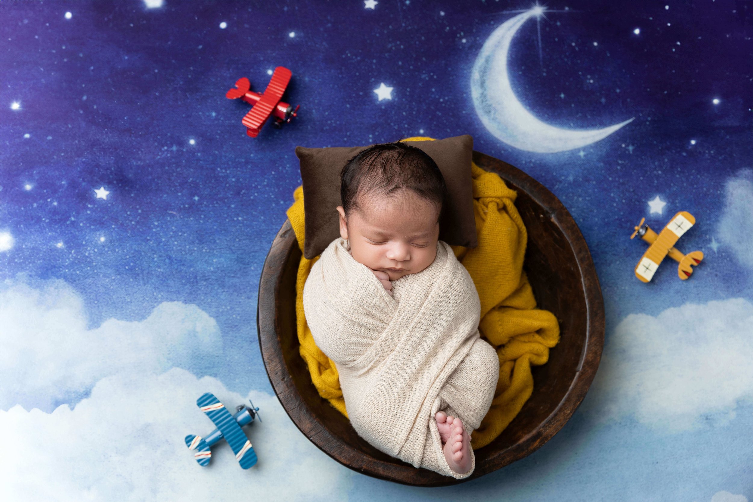 Wrapped newborn baby photographed in a neutral studio by a Frisco TX newborn photographer