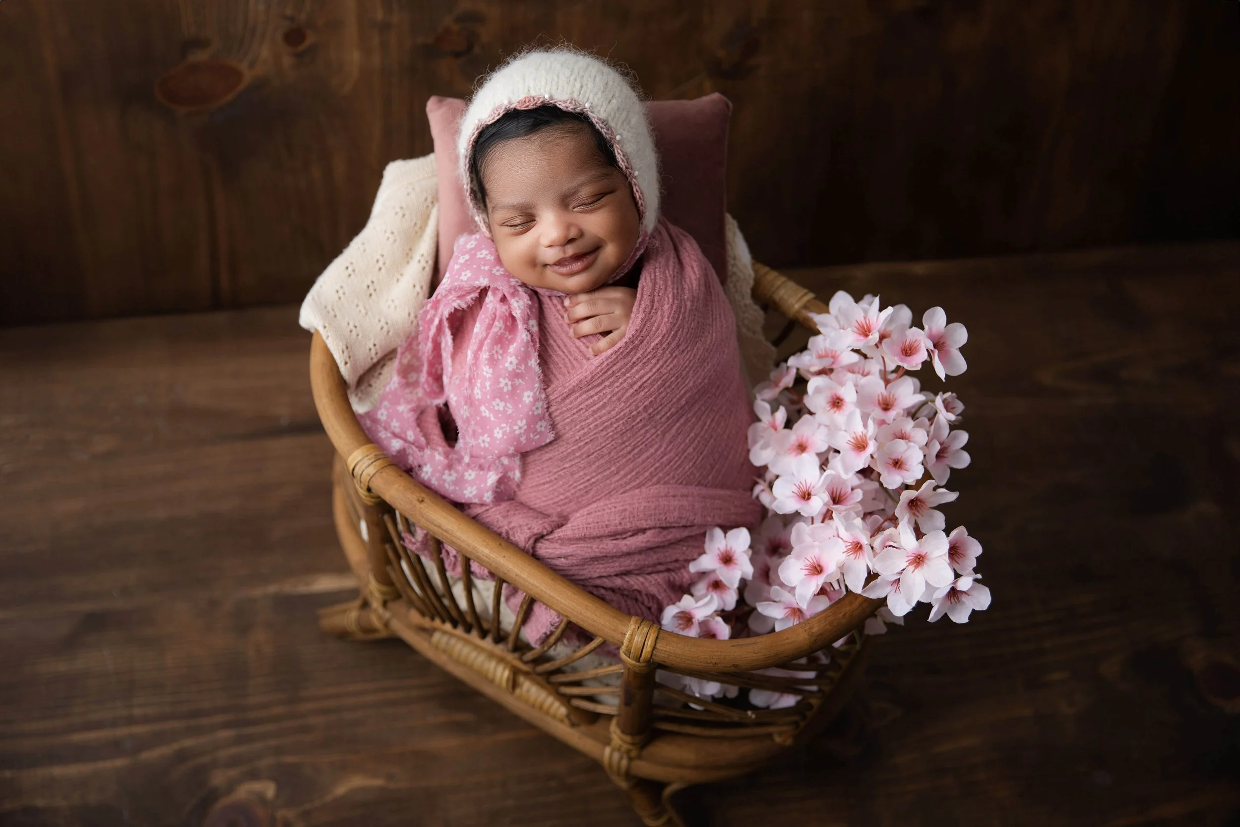 mauve pink newborn in a basket and wooden backdrop