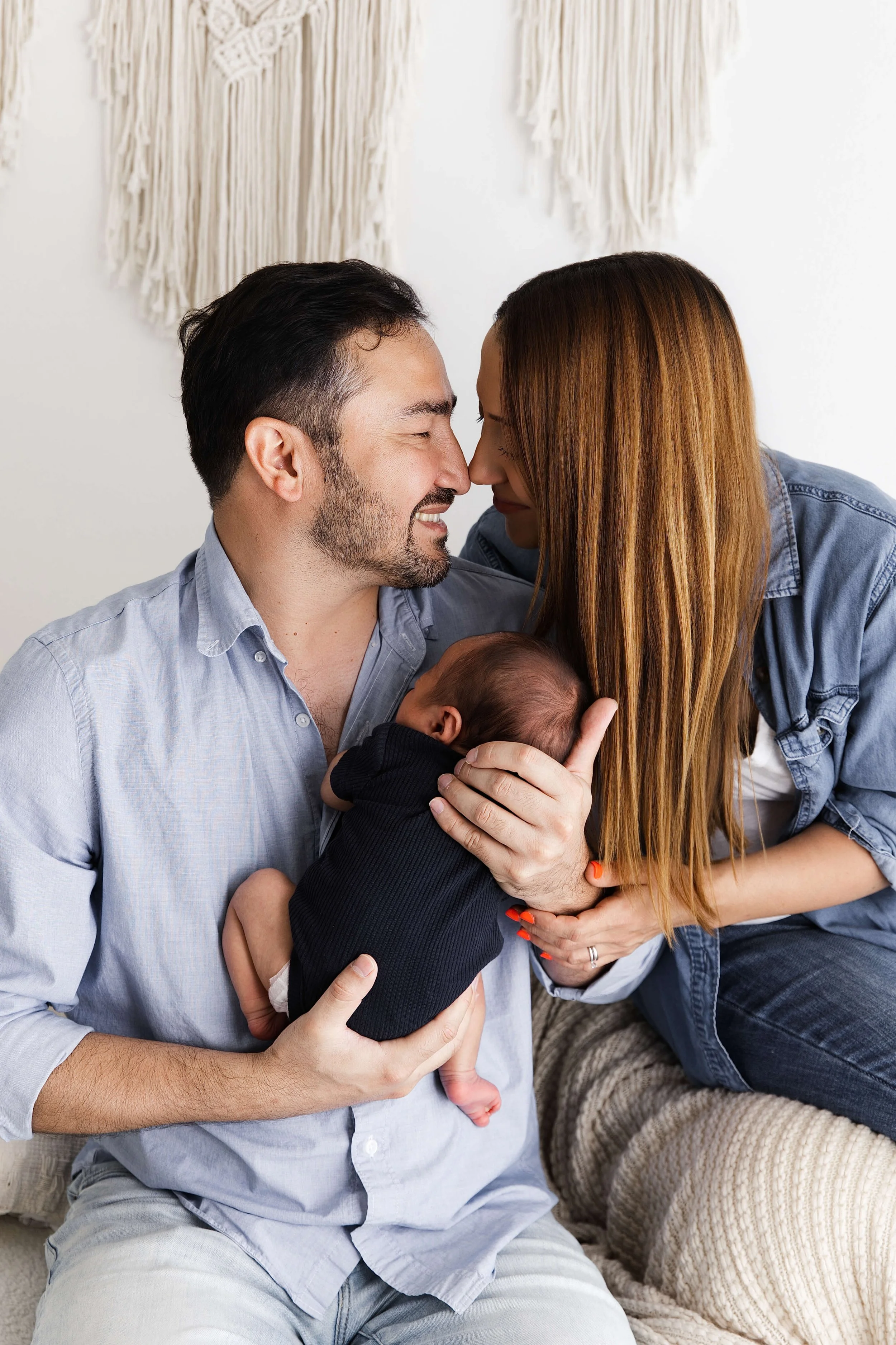parents cuddling with baby