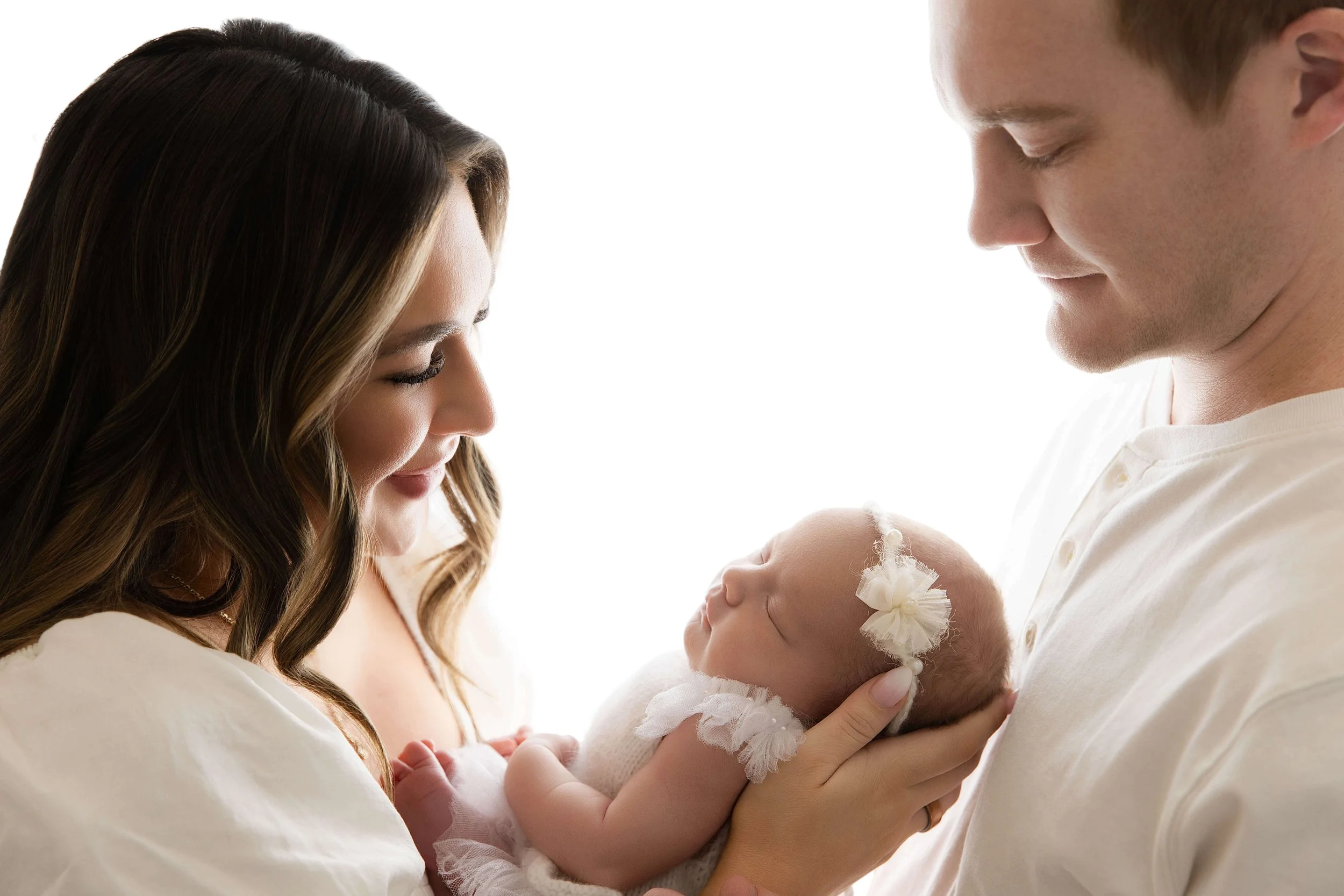 new parents looking down at their baby girl