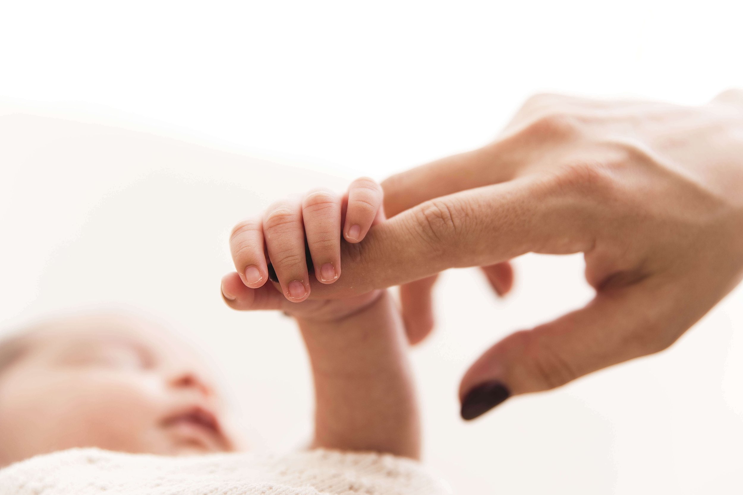 mom holding baby hand