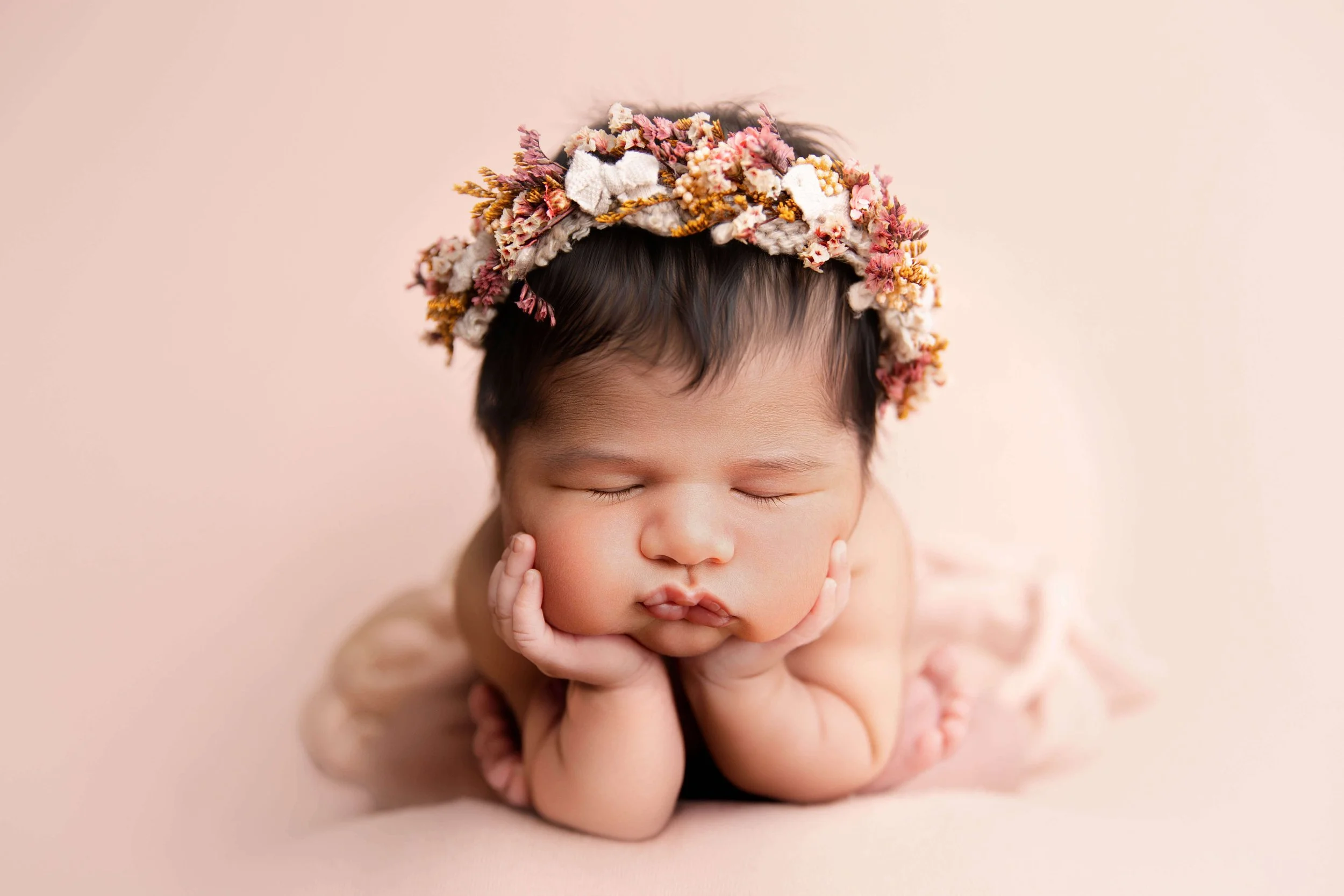 Newborn baby under 2 weeks old posed in a studio