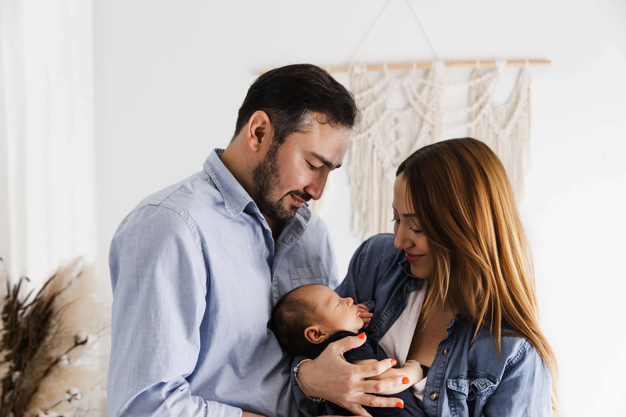 parents looking down at baby boy sleeping