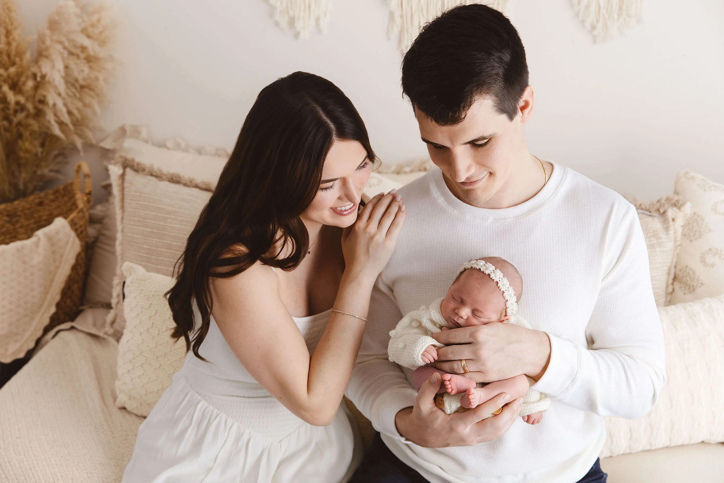Boho style mother and father holding their baby girl in a luxury studio