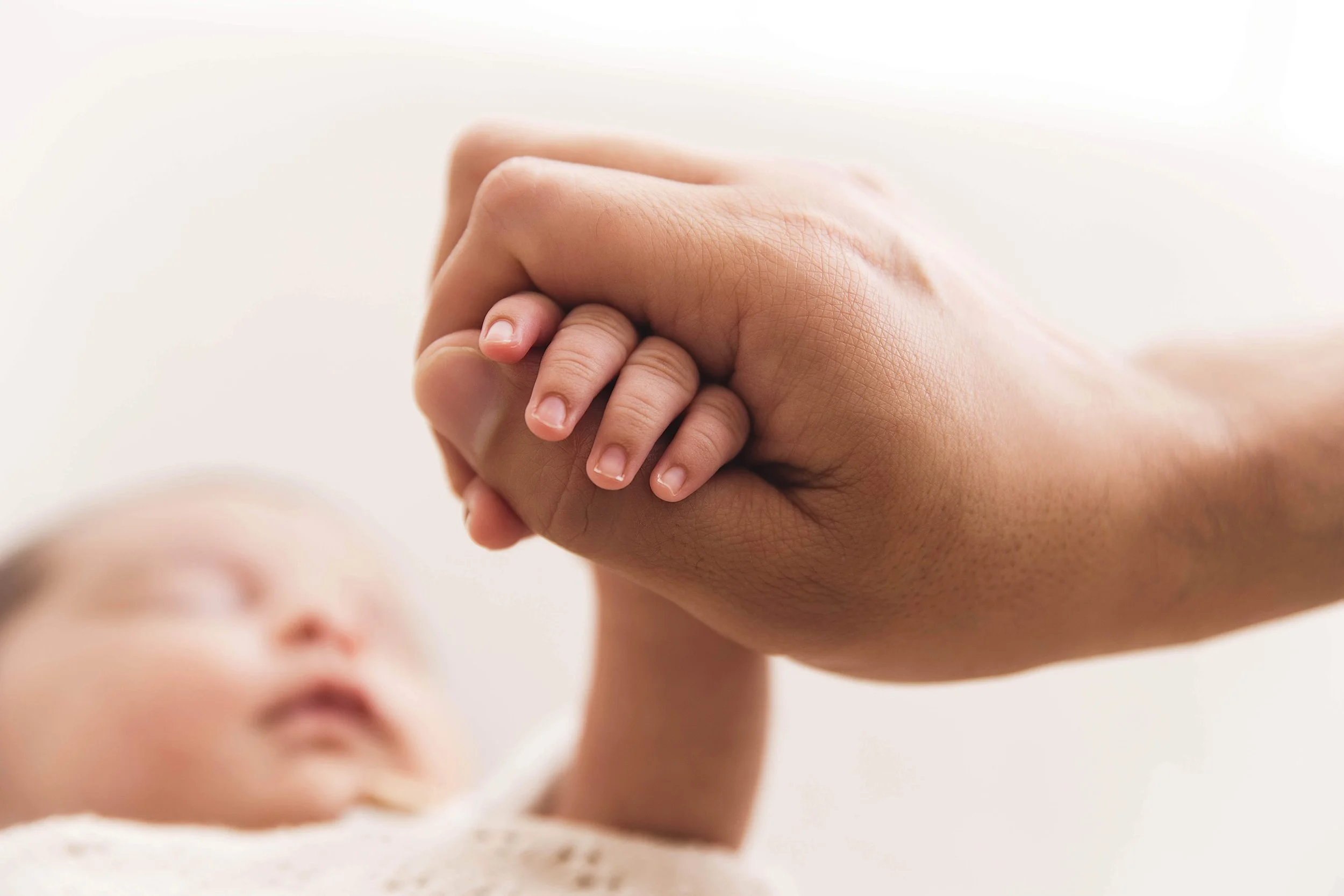 dad holding baby hand
