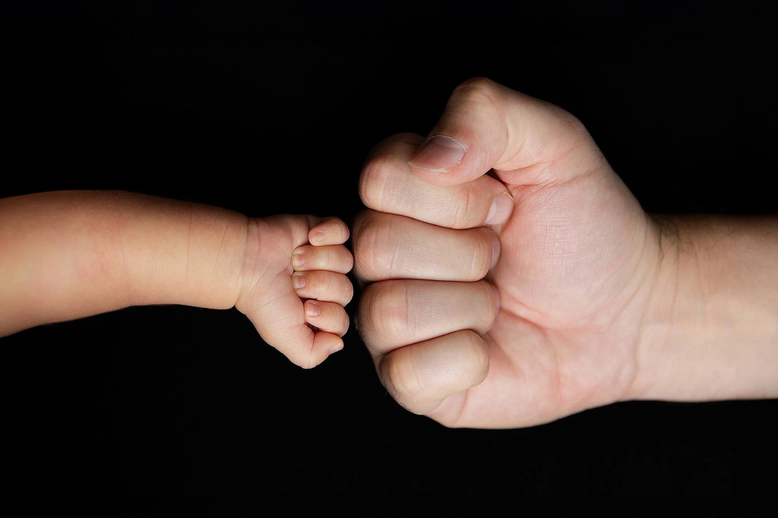 detail shot of baby and dad's hand