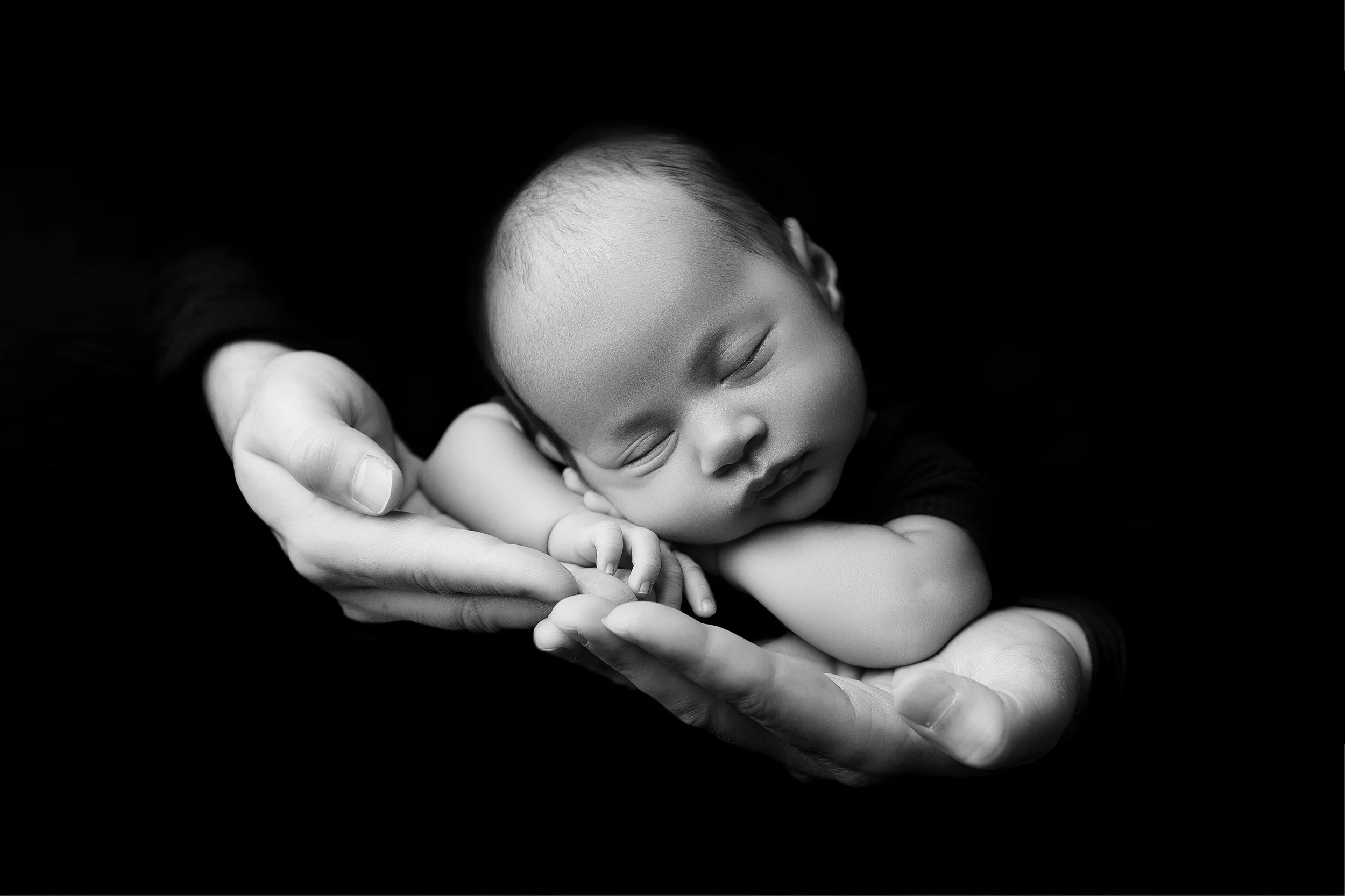 black and white baby in dad's hands