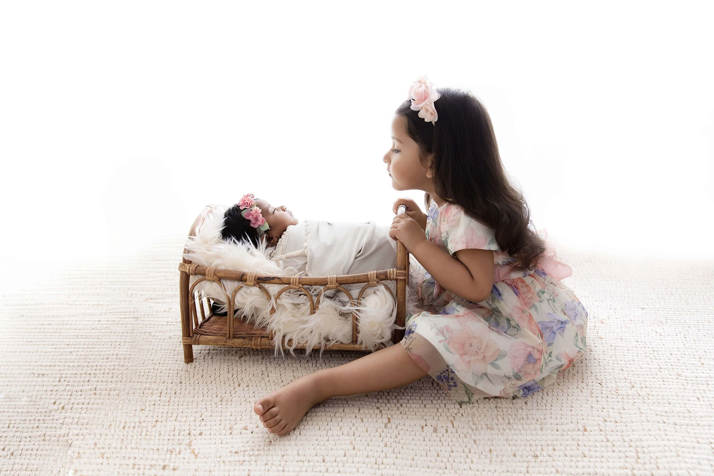sibling with newborn baby in basket