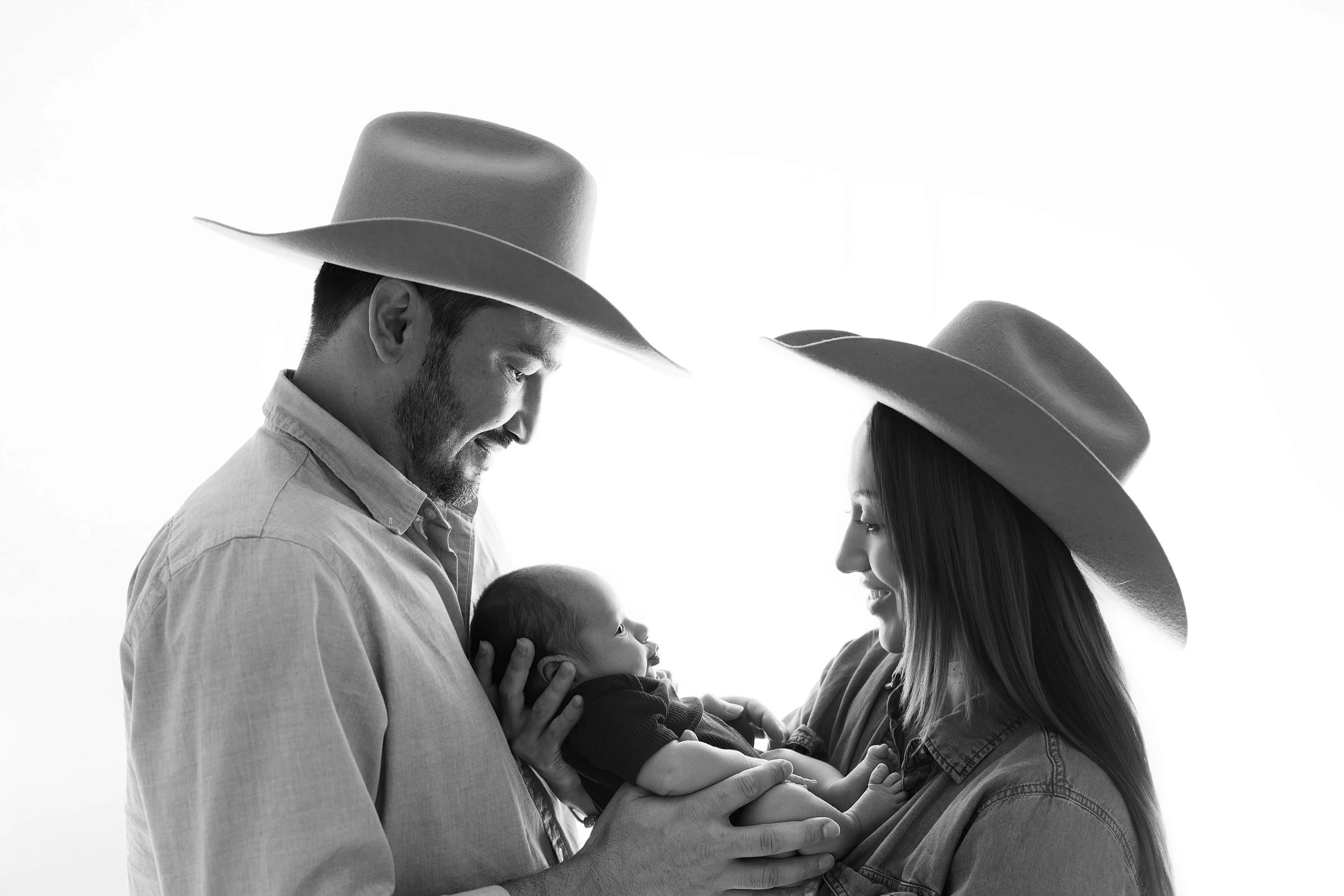 black and white parents looking at newborn