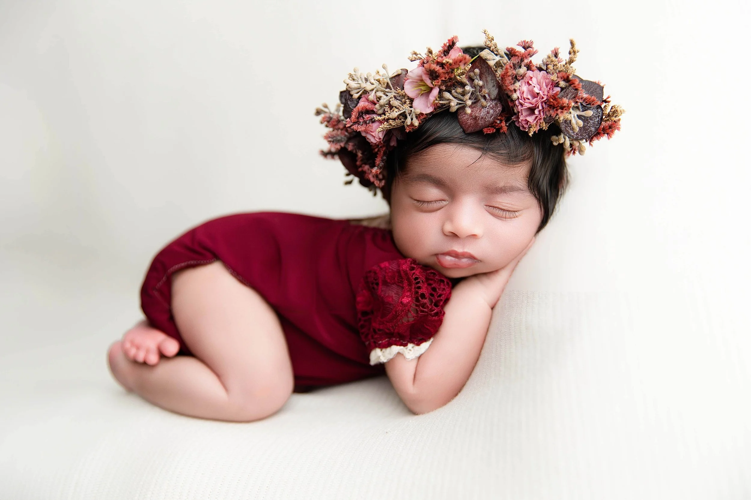 baby in a bum up pose wearing red