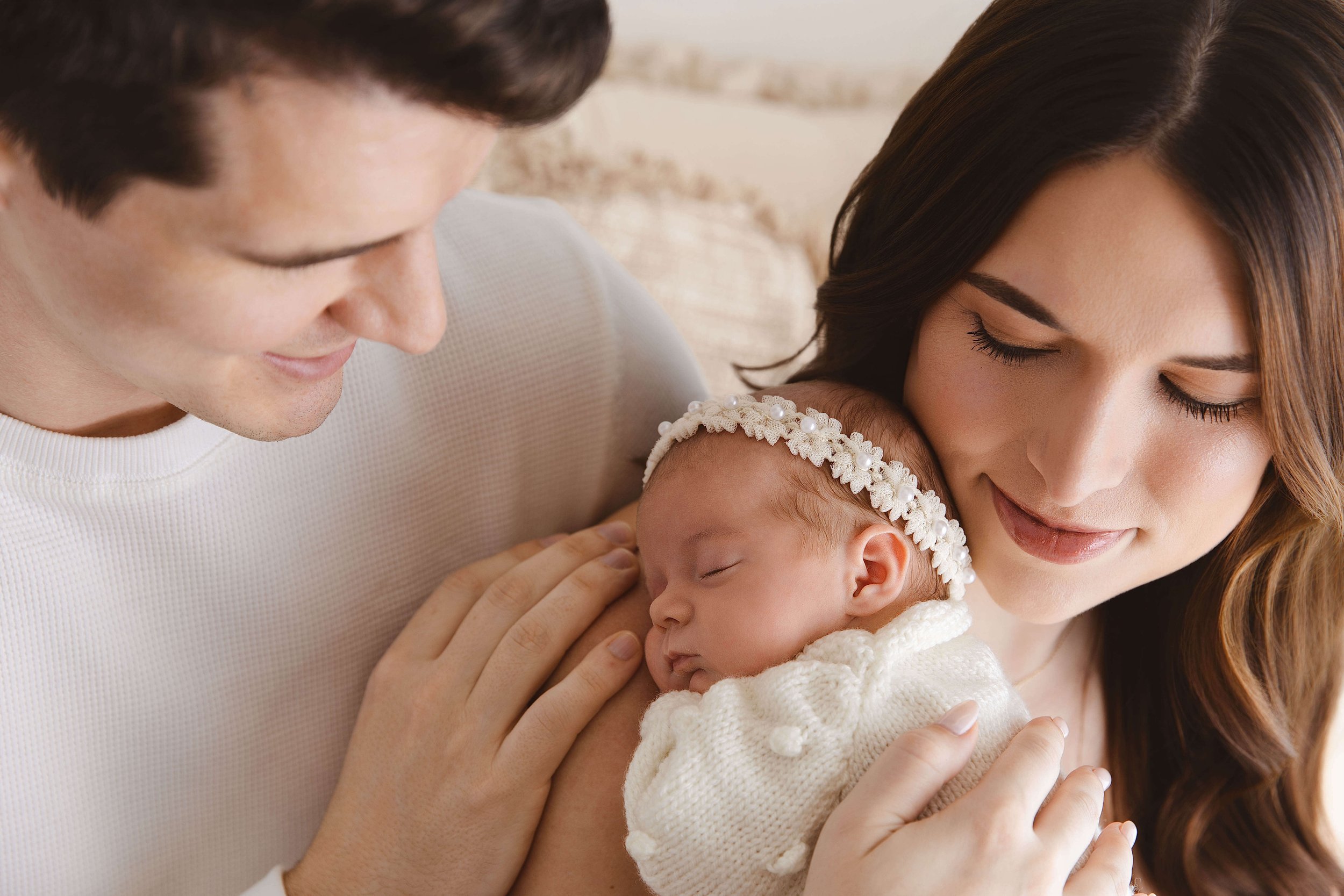parents looking down at their baby girl and cuddling