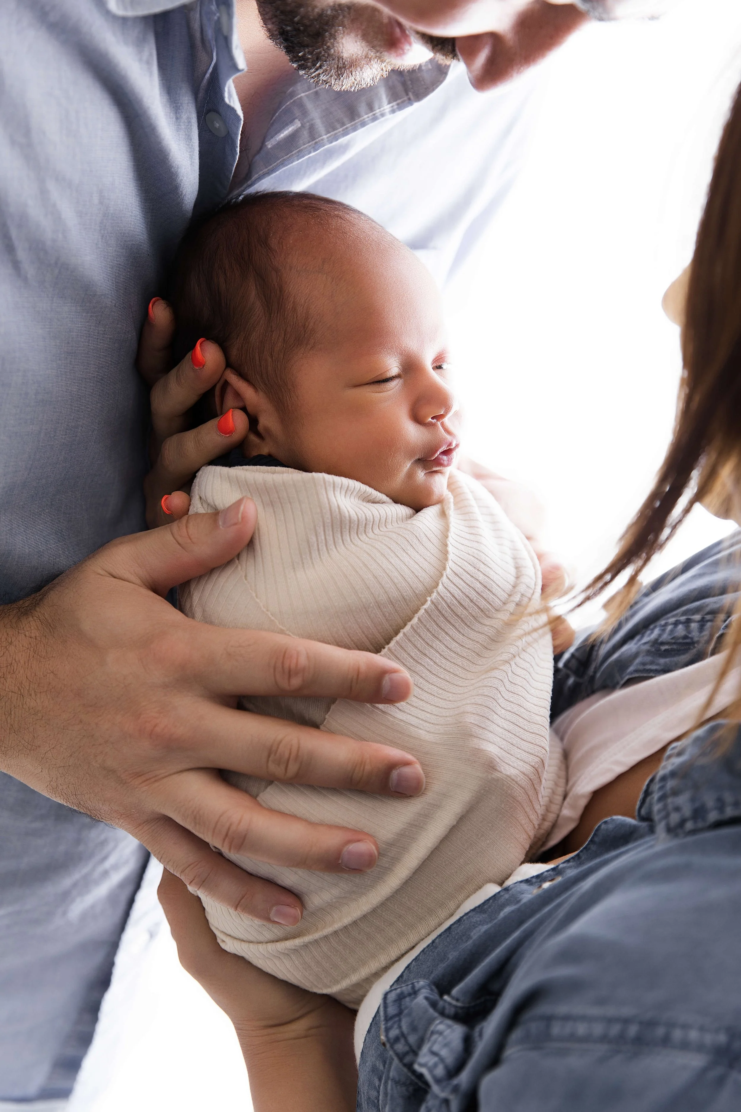 parents holding wrapped baby