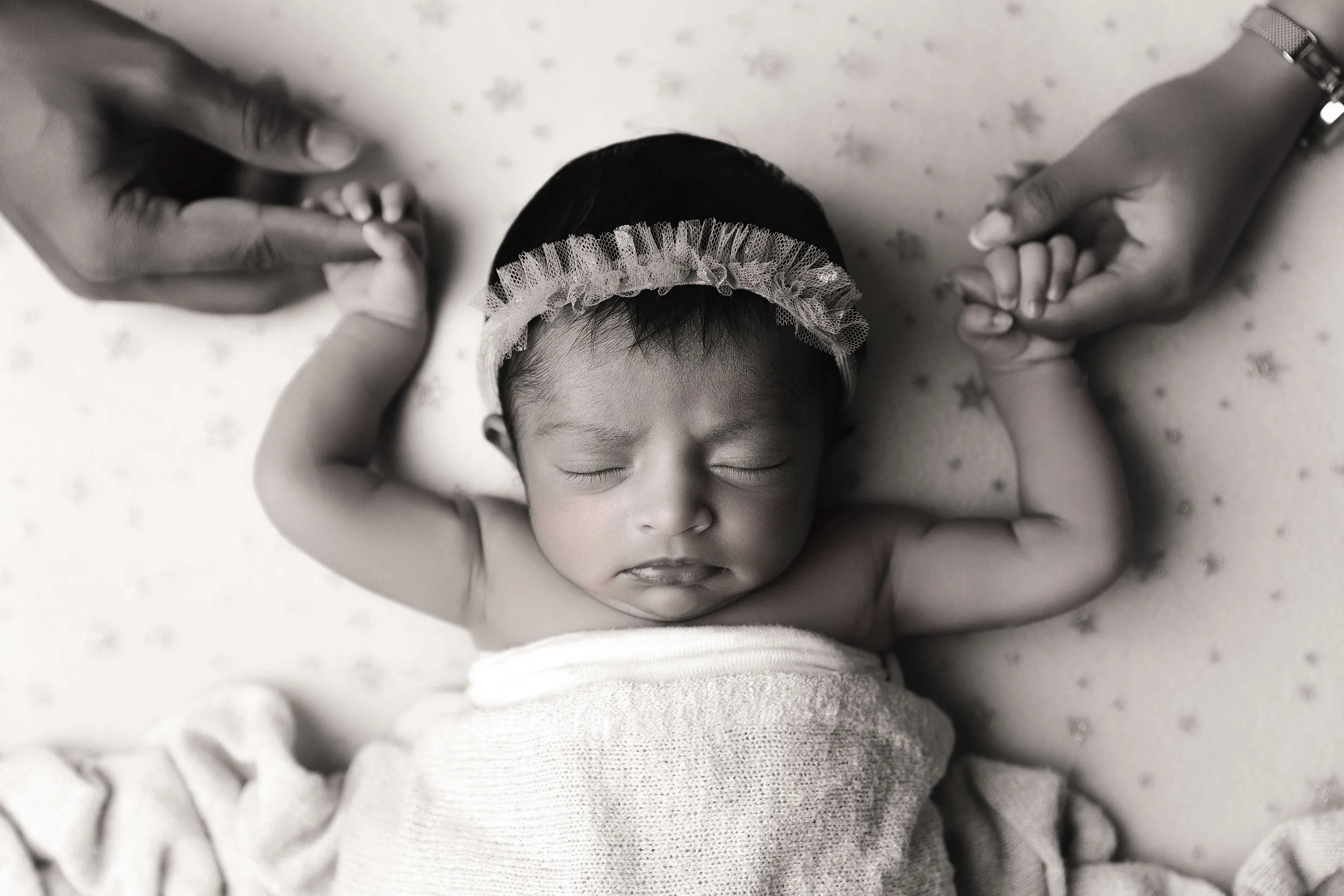 parents holding baby's hands