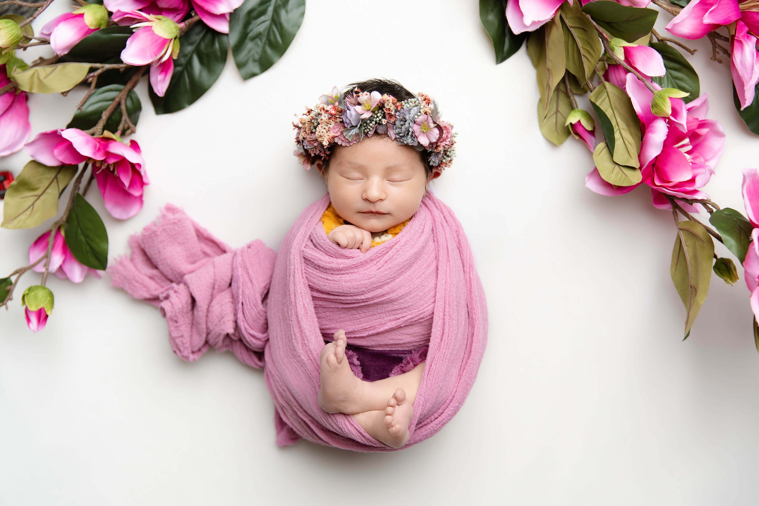 baby in a pink setup with pink flowers