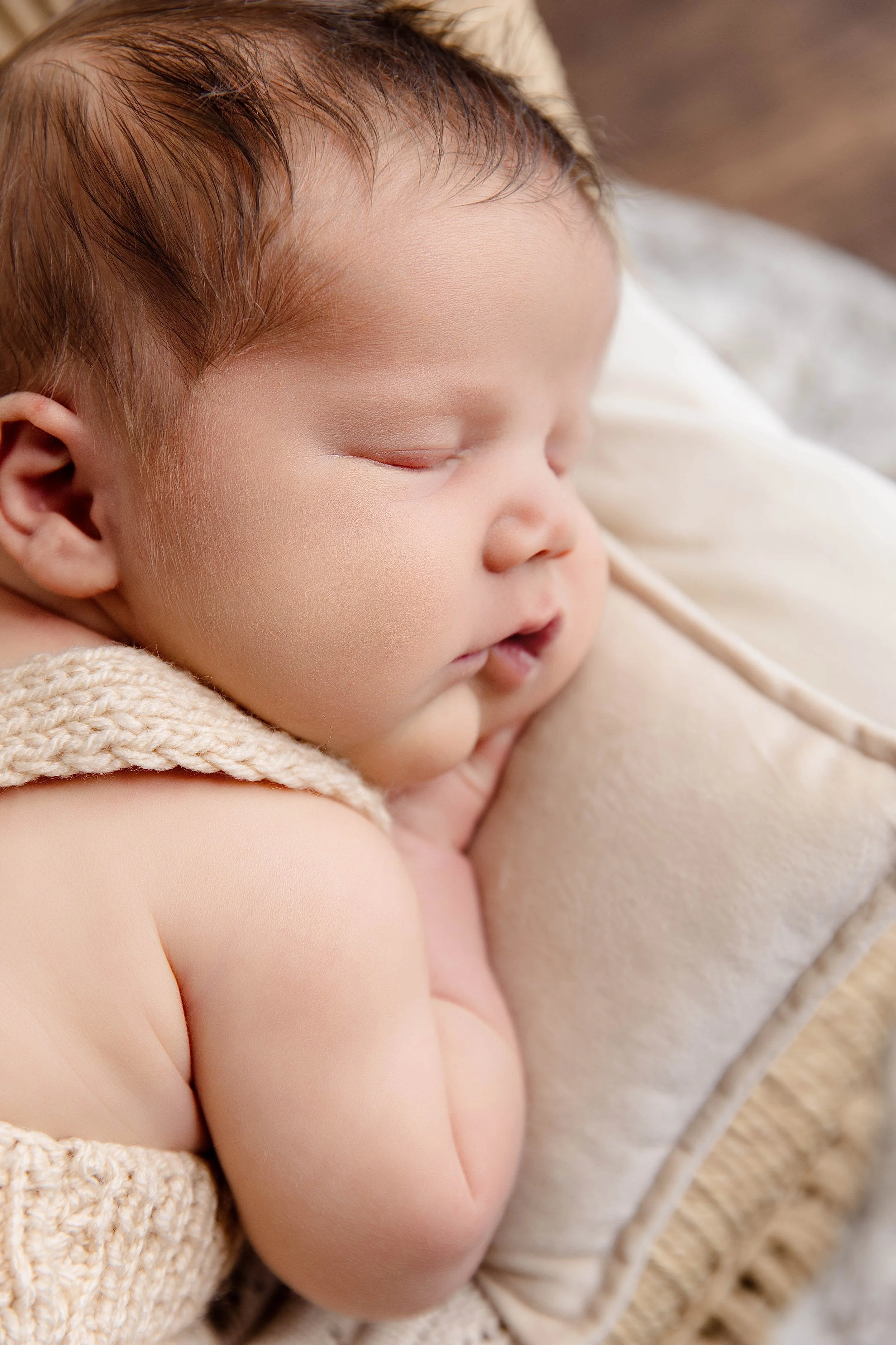 A sleeping baby with red hair resting on a soft pillow.