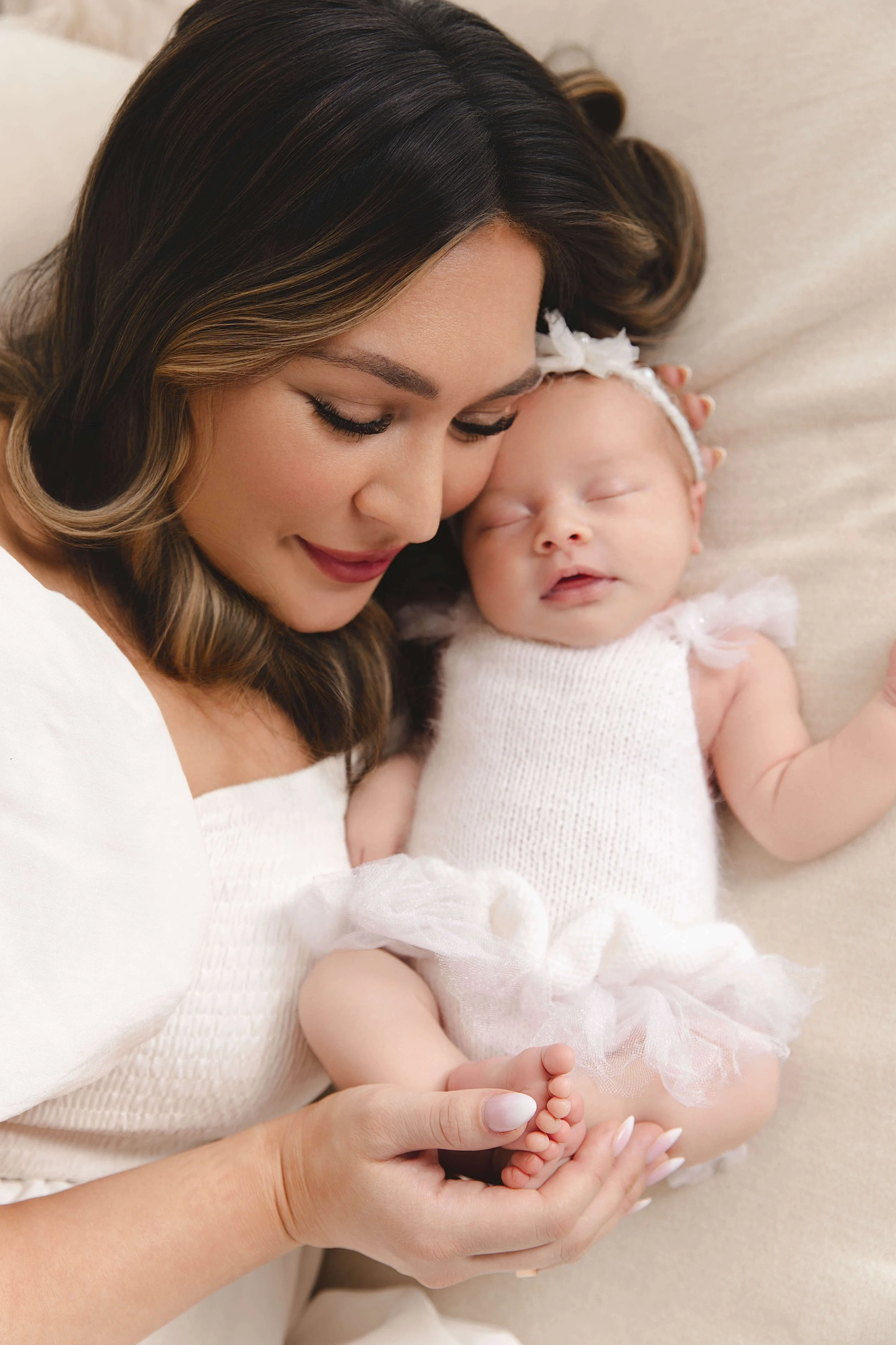 mom cuddling with baby wearing neutral colors