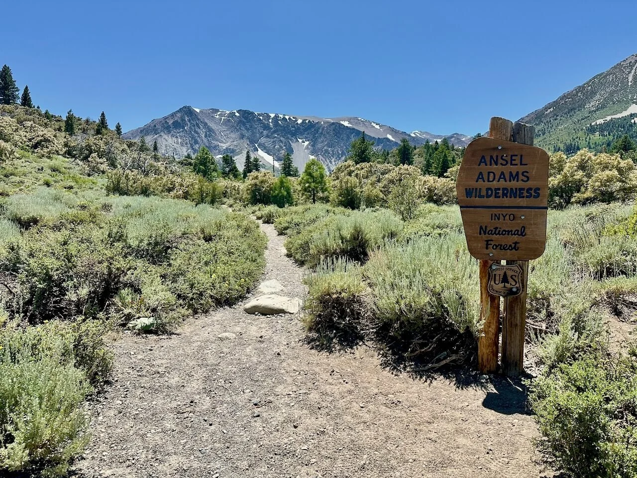 Parker Lake Trailhead sign with a panoramic view of the Eastern Sierra Nevada mountains, sagebrush scrub of the Mono Basin in the foreground.