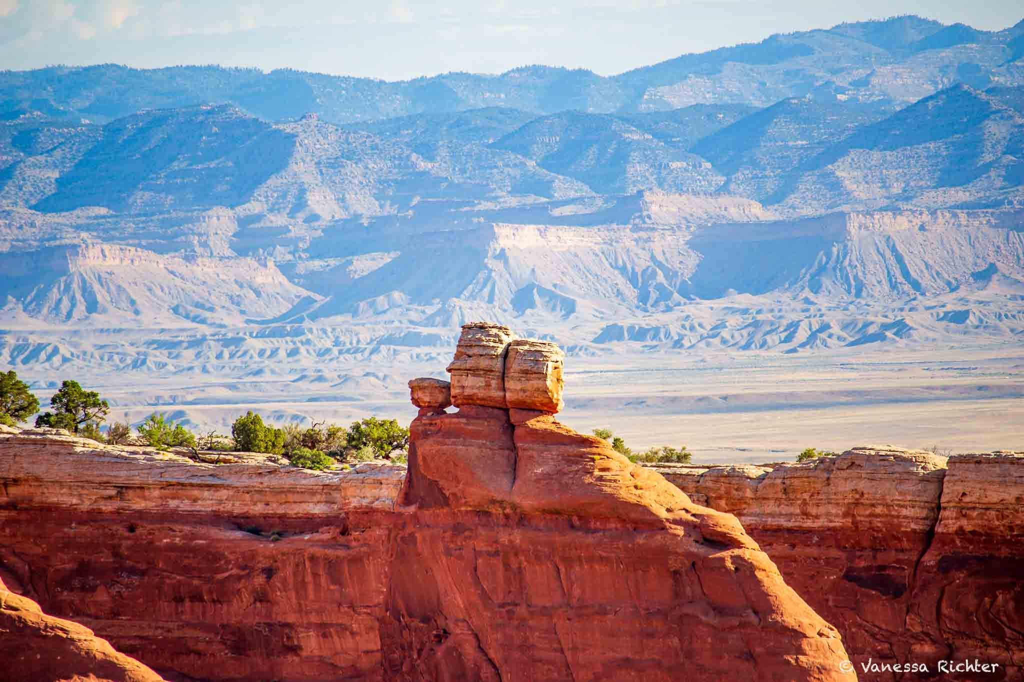 Rock fins and formations resembling faces along the Devils Garden Trail, canyon views in the background