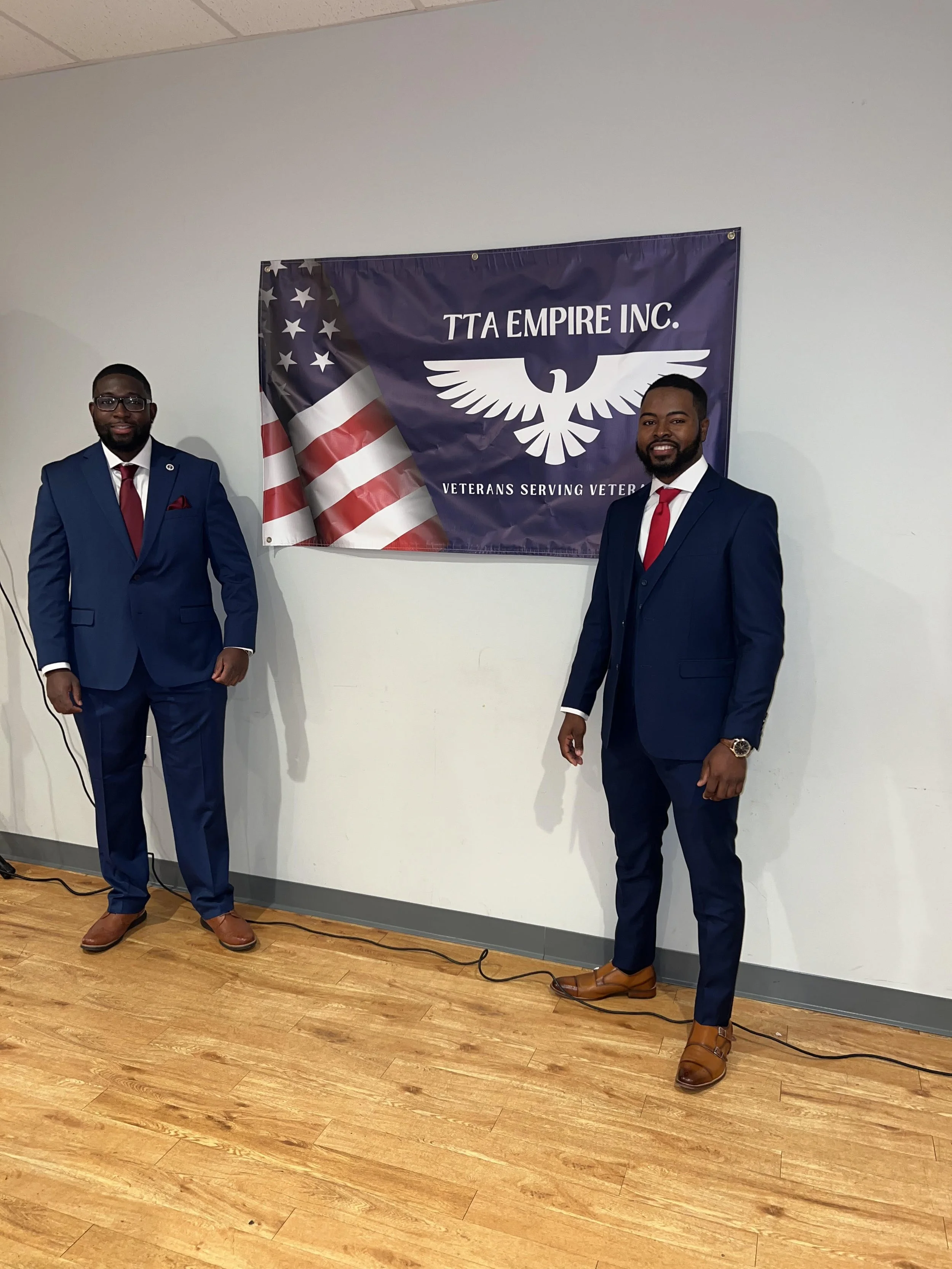 Timothy in front of TTA Empire flag with another man
