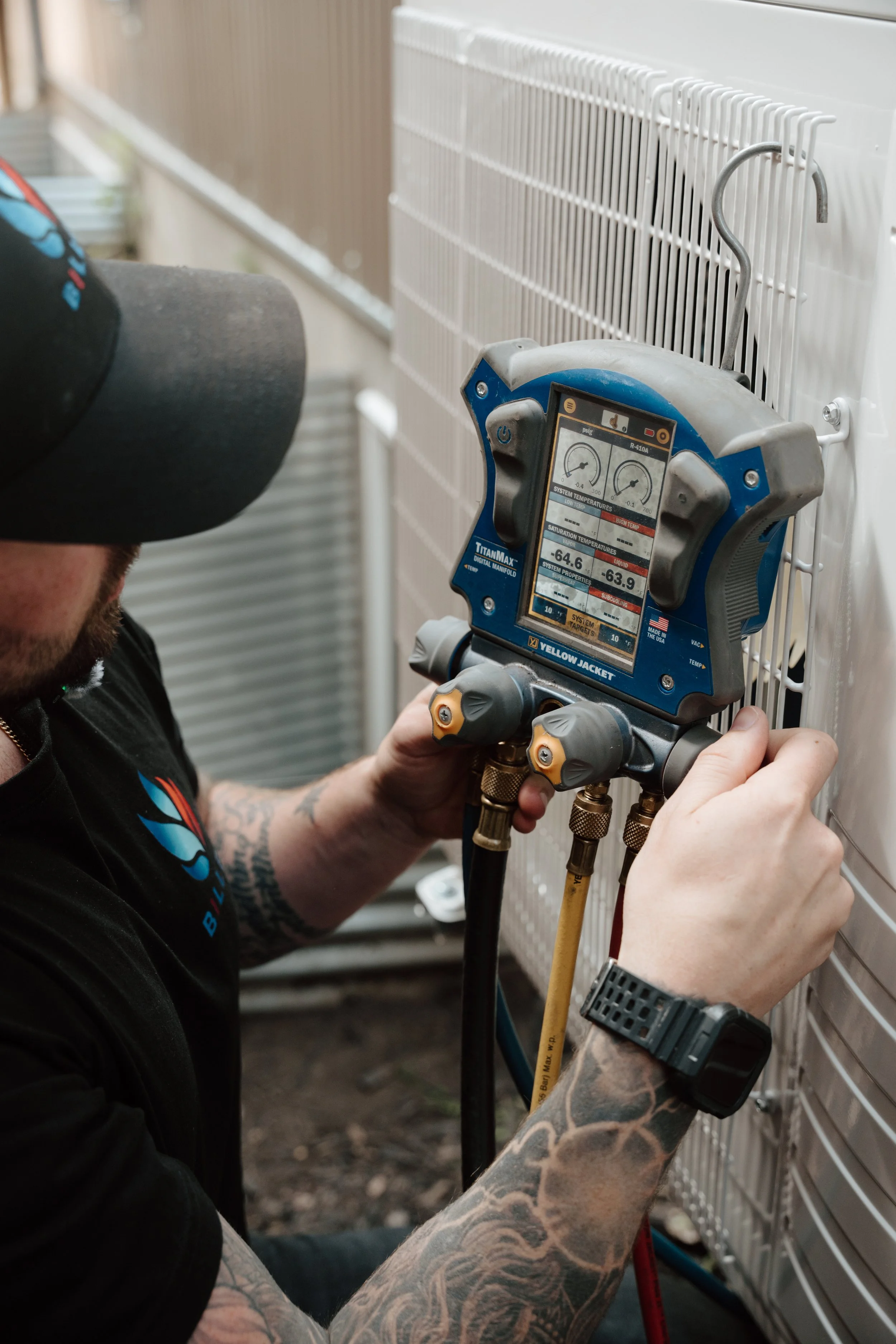 Edmonton air conditioner service professional from BILLEE Heating & AC uses a Yellow Jacket HVAC tool on an air conditioning unit