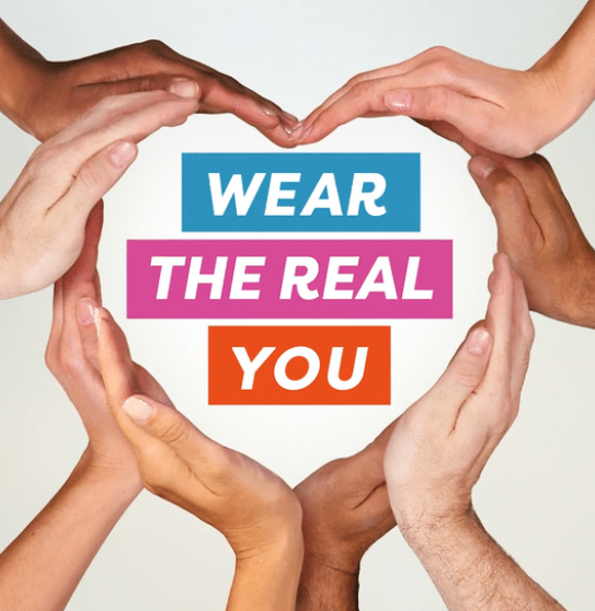 Multiple hands forming a heart shape around a message that reads 'Wear the real you' in colorful text.