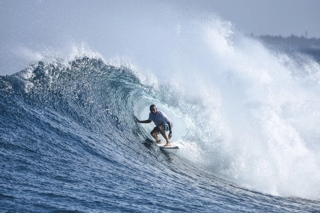 A surfer getting barrelled on a perfect right hand wave in the Maldives