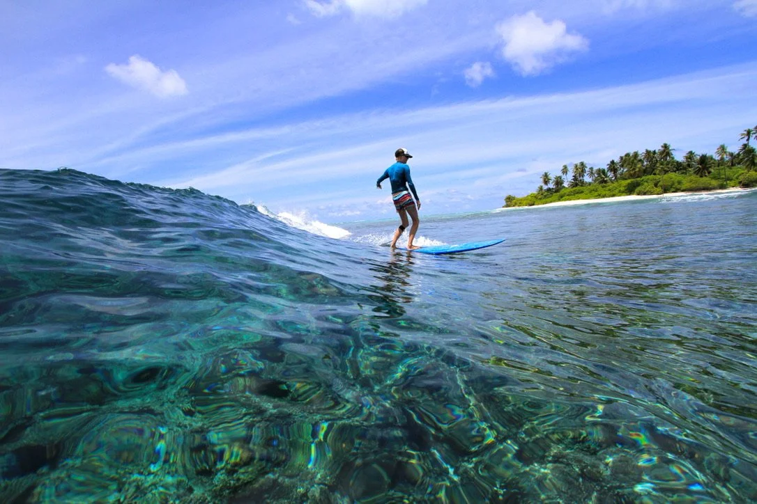 An intermediate surfer on a perfect wave in clear tropical water
