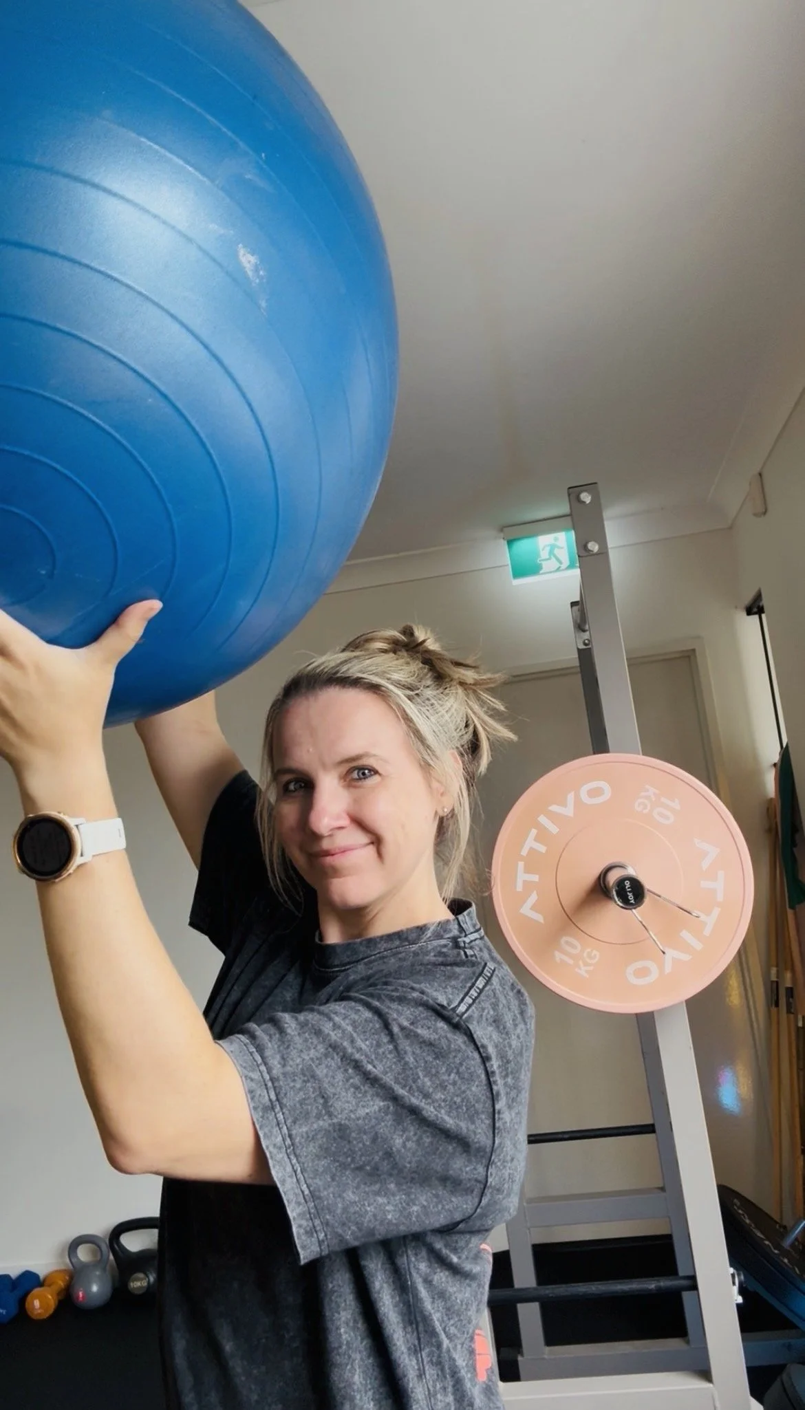 People practicing yoga outdoors on a wooden deck by a lake, in a forward bend pose on yoga mats.
