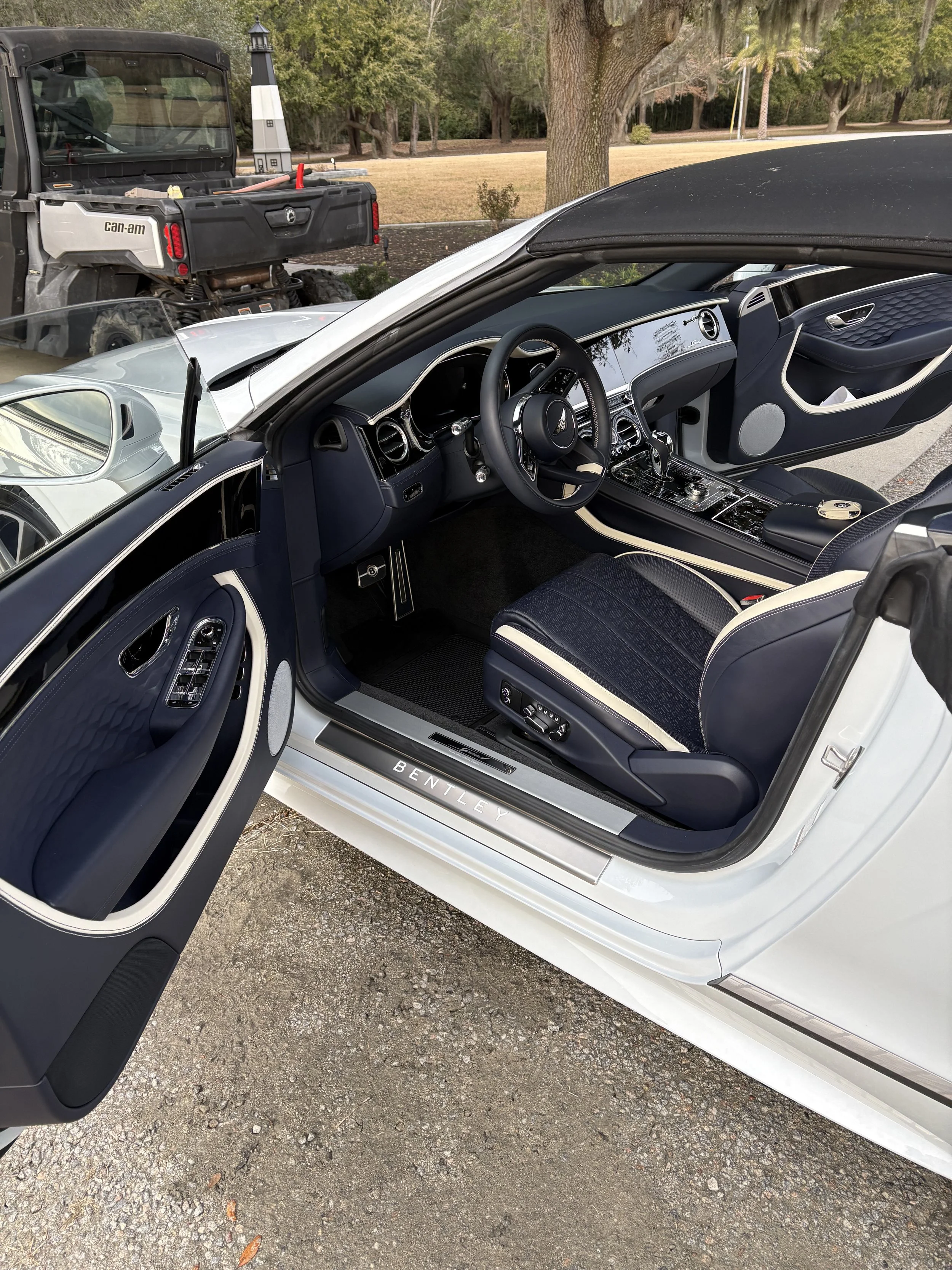 The interior of a luxury white Bentley car with navy blue and cream accents after a detail in beaufort