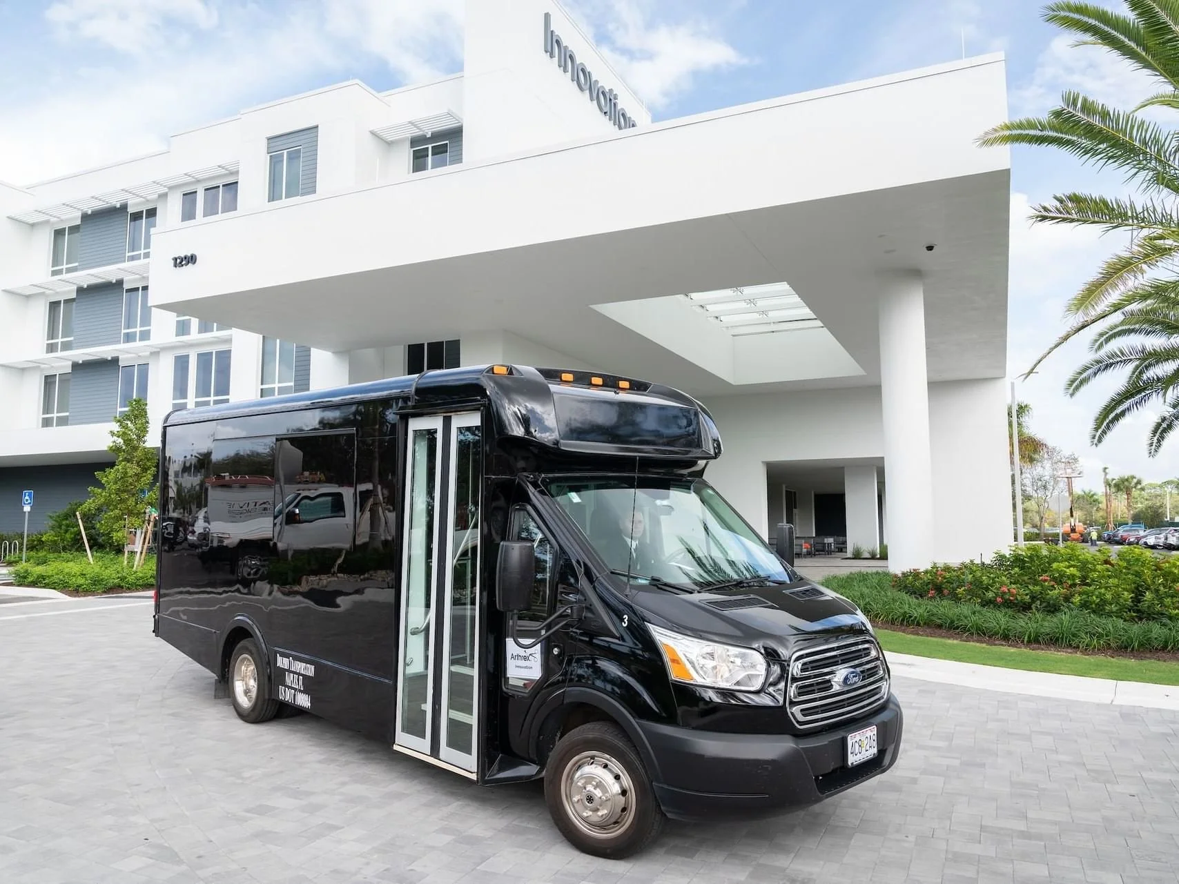 Black ford transit shuttle parked in front of a hotel