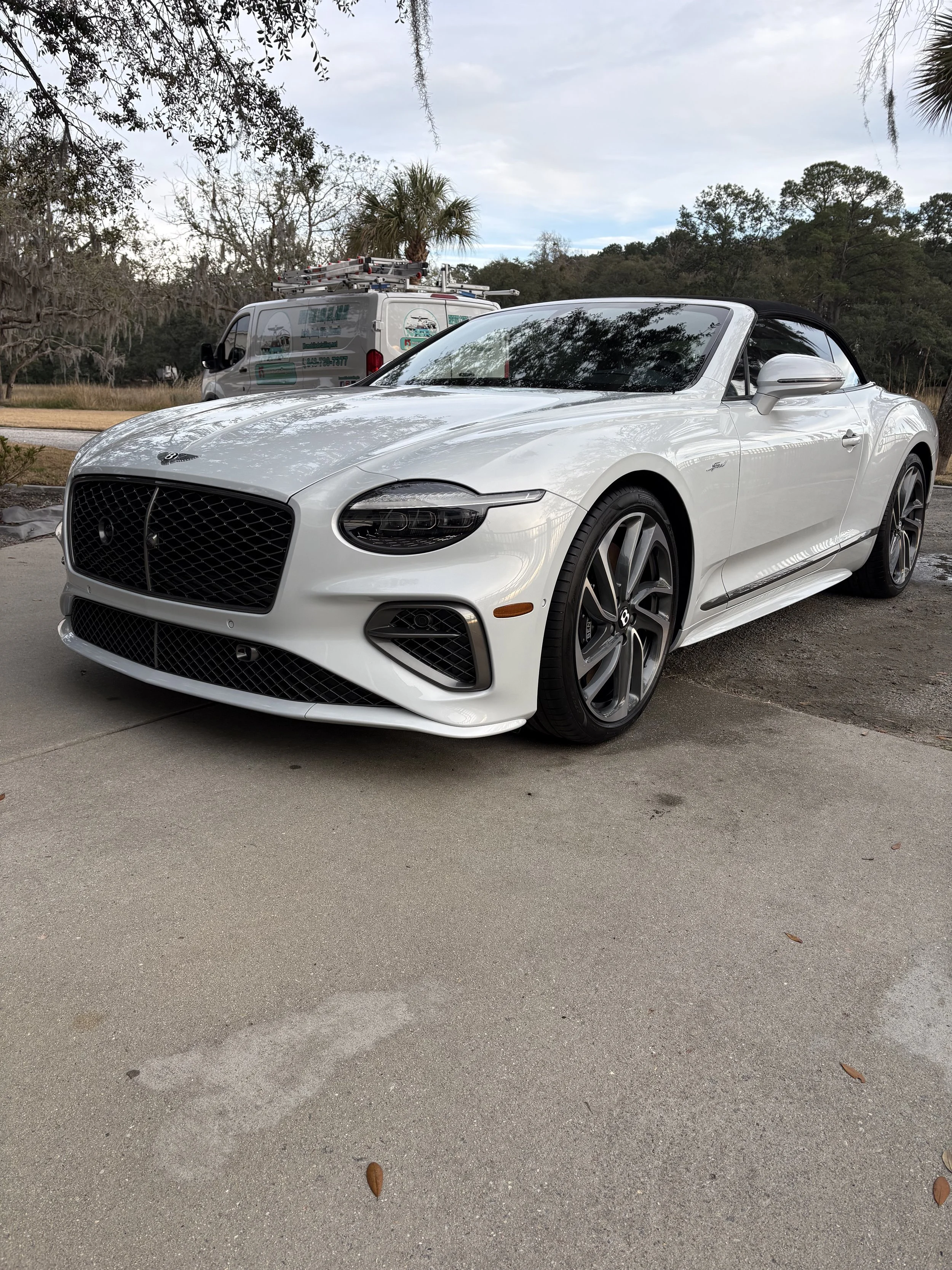 A white Convertible luxury car, likely a Bentley detailing in beaufort