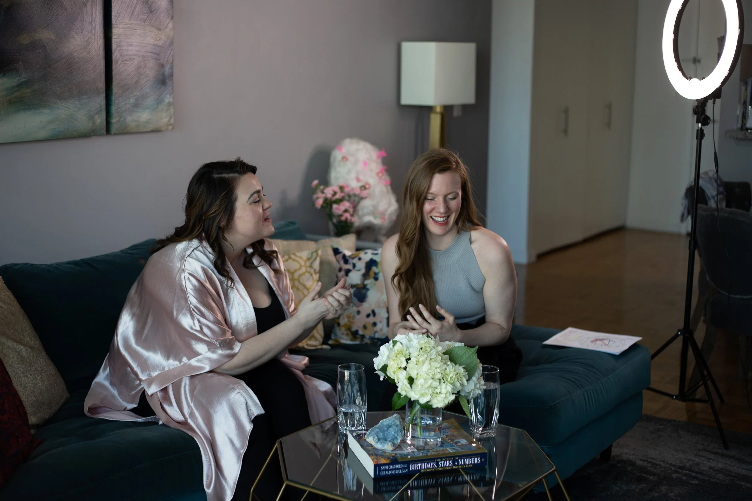Picture of Virginia laughing with another person on a couch in a real magic session