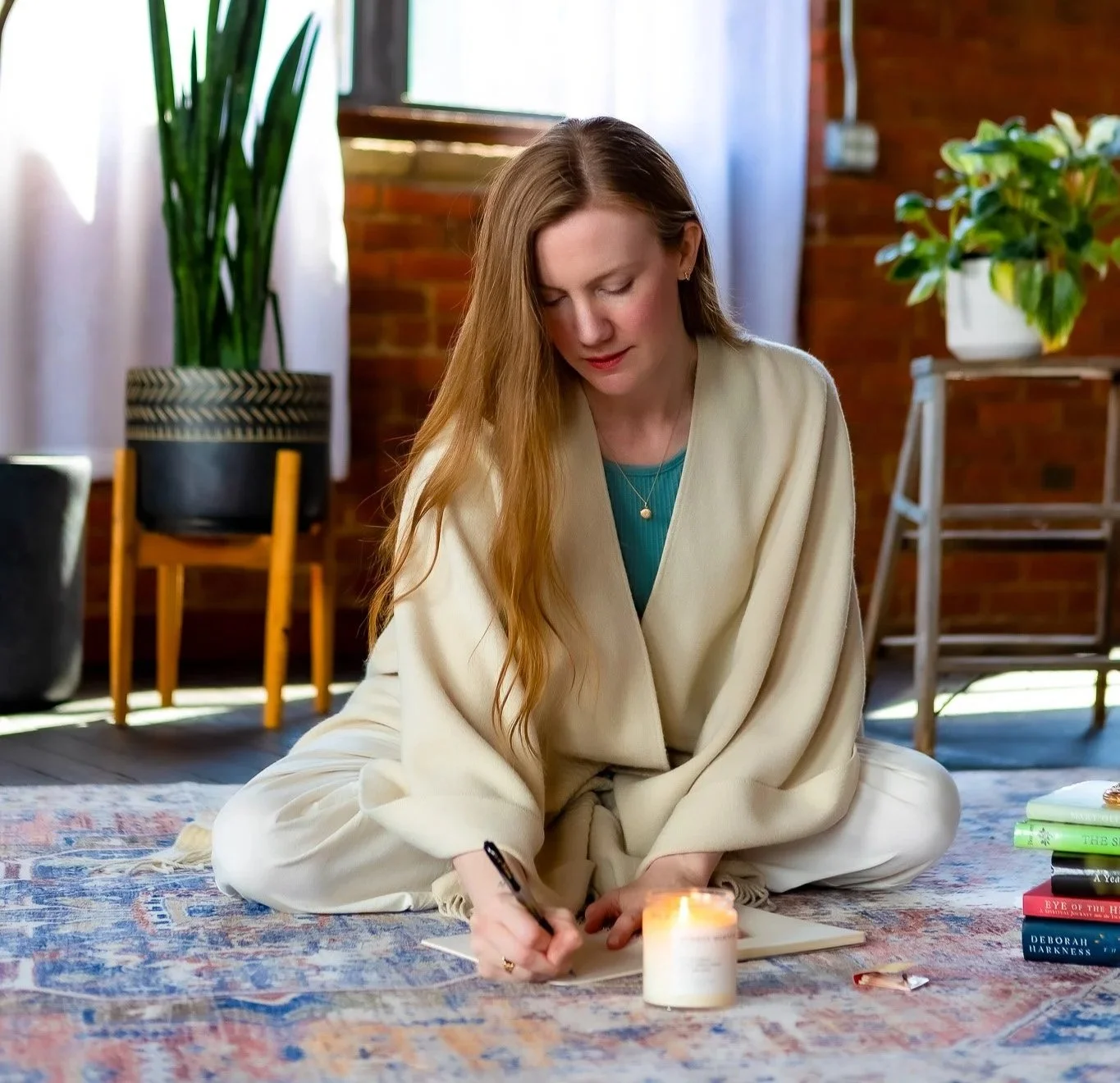 Virginia writing down what she sees as she channels and a candle burns before her