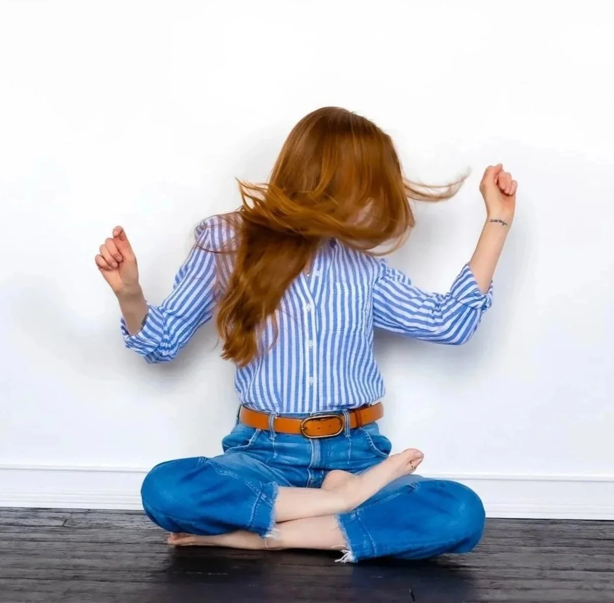 Picture of a woman sitting cross-legged dancing with joy and ecstasy