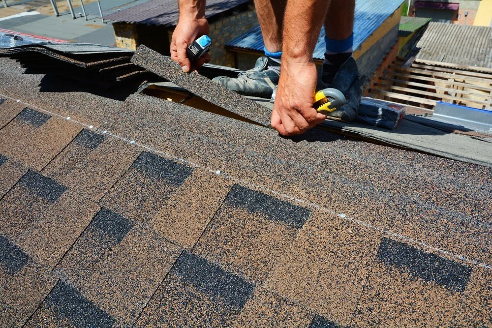 Roofing contractor installing asphalt shingles on residential roof in Calgary