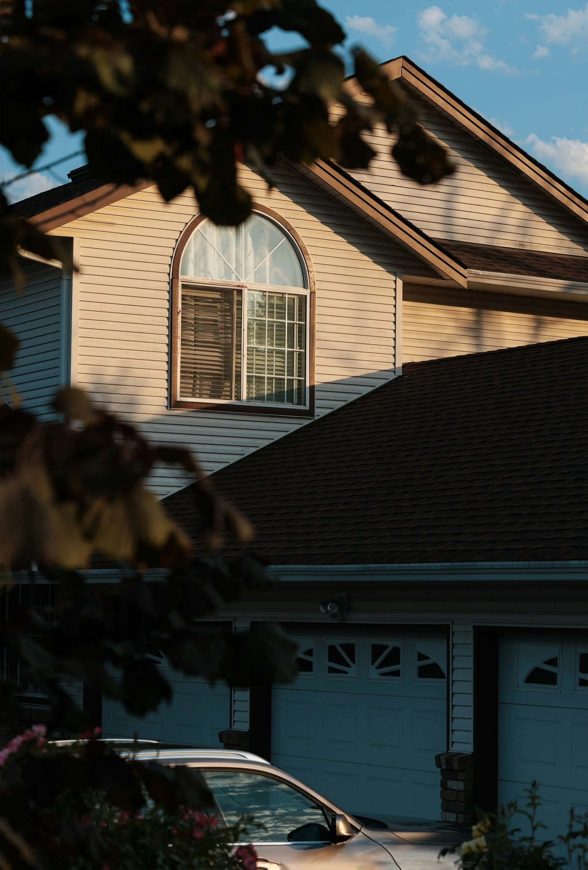 Residential asphalt shingle roofing on a Calgary home with dormer window, showcasing professional roof installation