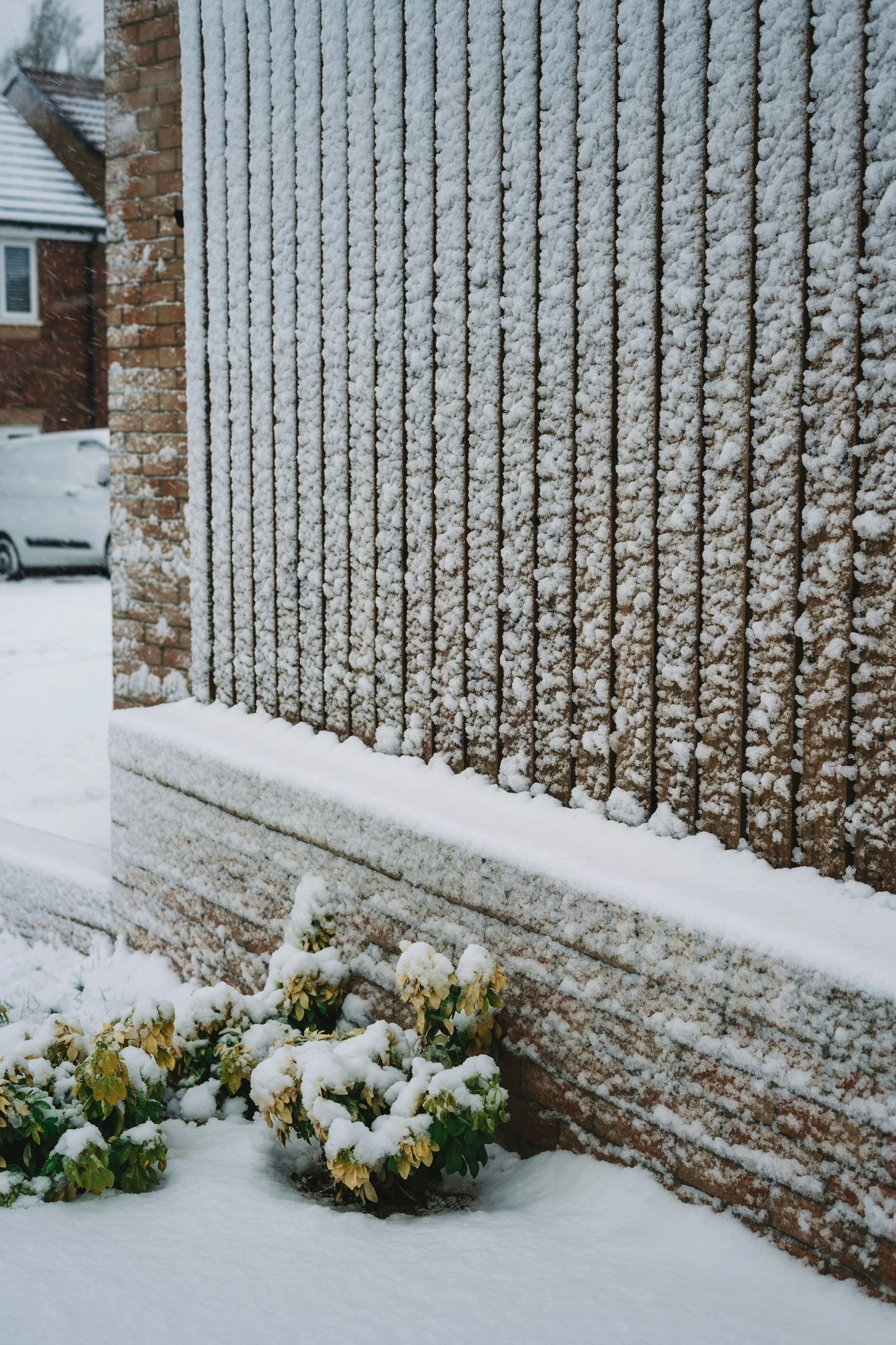 Snow accumulation on a residential building wall and ledge in Calgary during winter conditions