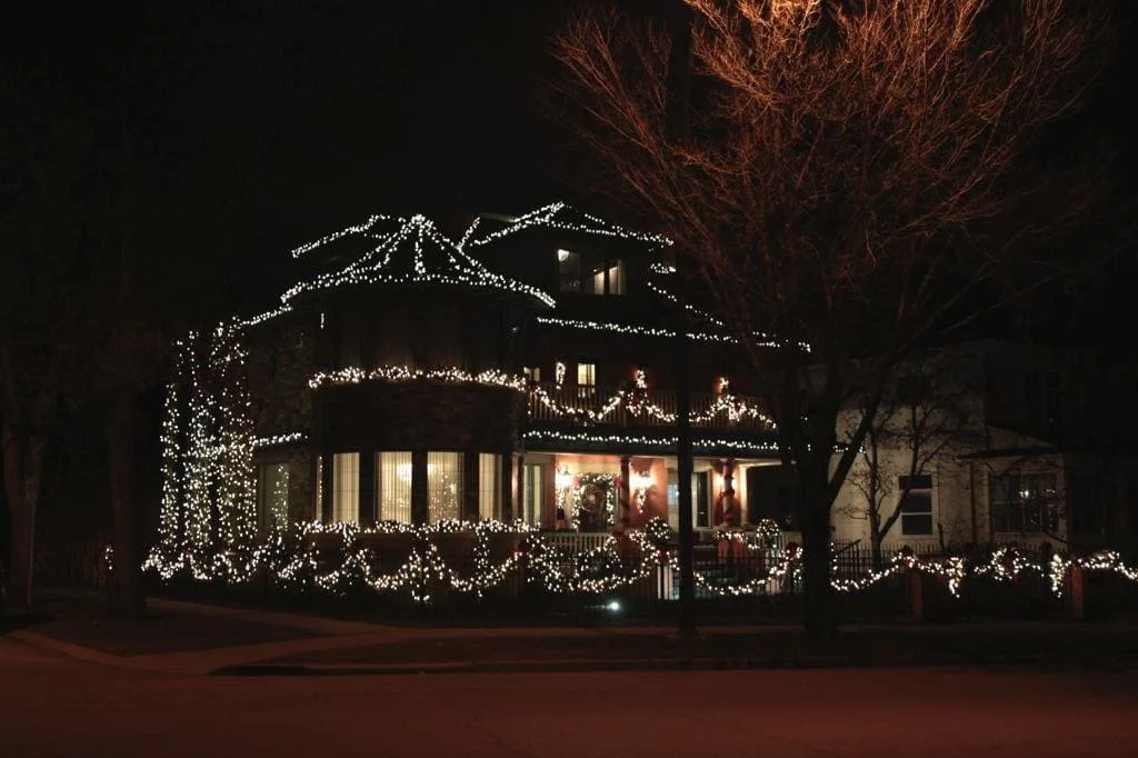 Professional Christmas light installation on Crescent Road in Calgary with warm white roofline, tree, and garland lighting