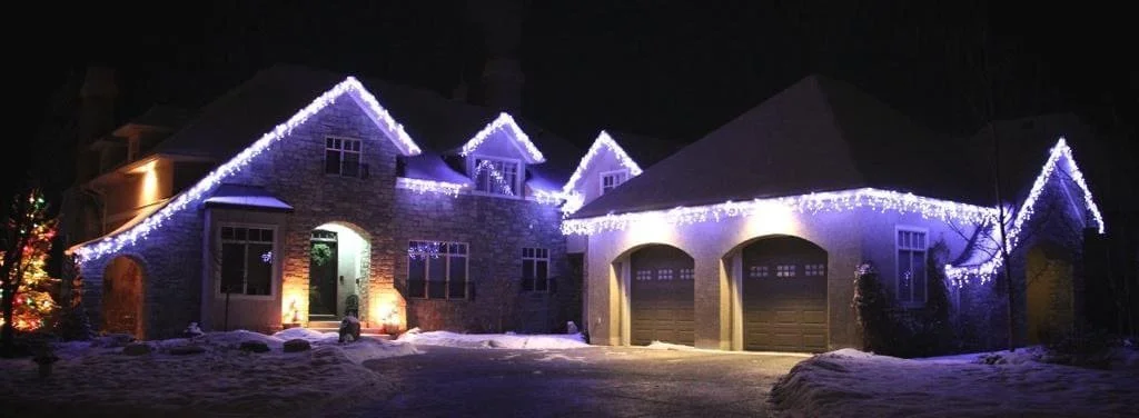 Residential home in Calgary with pure white icicle Christmas lights installed along roofline by a professional lighting company