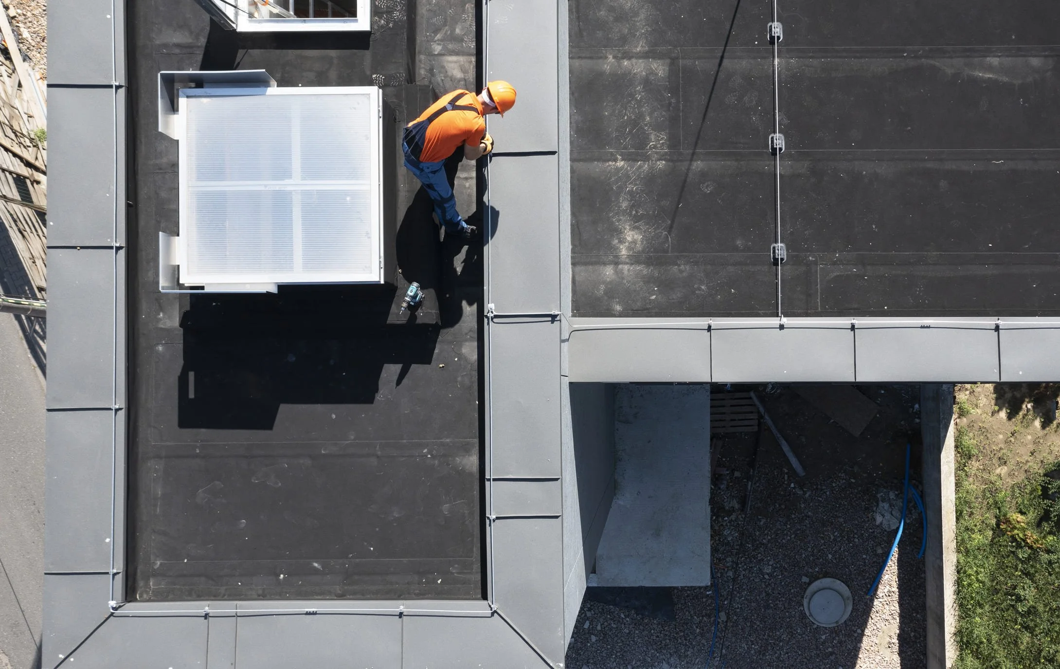 Technician inspecting commercial flat roof for maintenance in Calgary