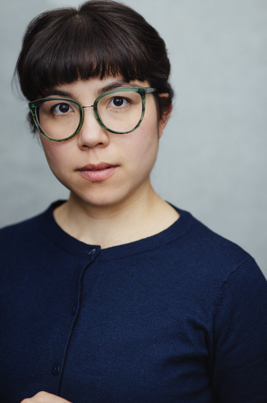 Headshot with glasses in blue cardigan by Joss Ryder