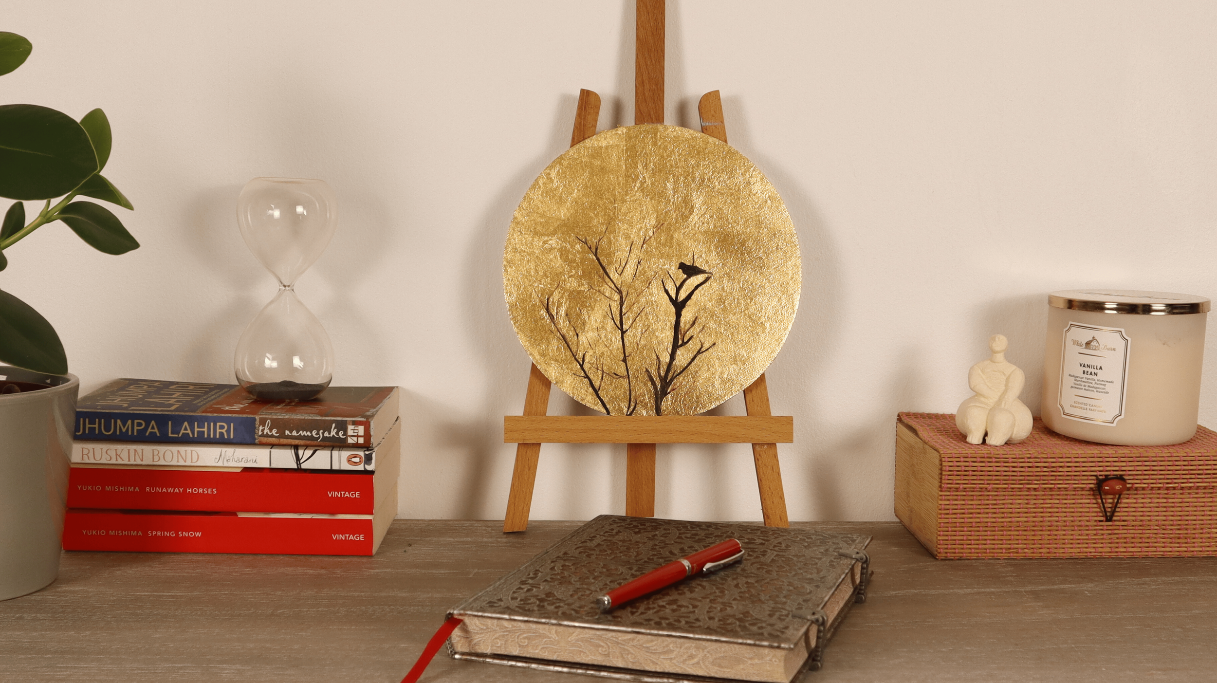 Gold leaf round painting displayed in a minimalist interior from distance