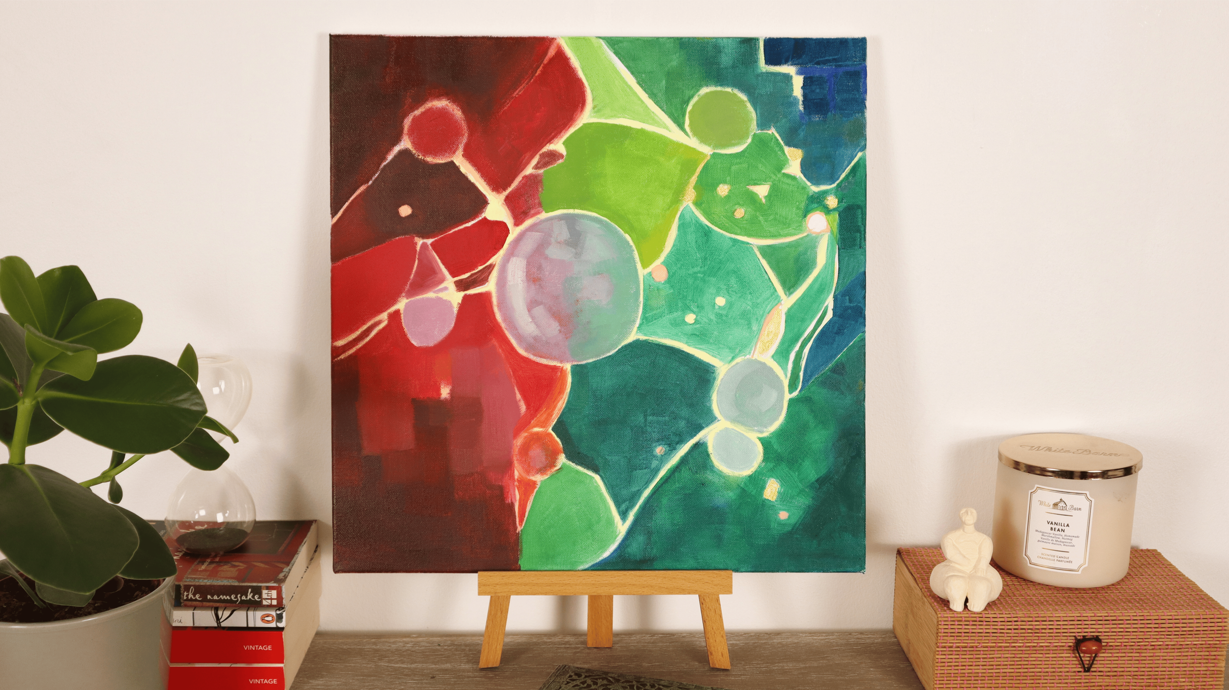 Abstract contemporary painting titled “First Thought” displayed in a modern interior, showing interconnected organic forms and a luminous color palette.
