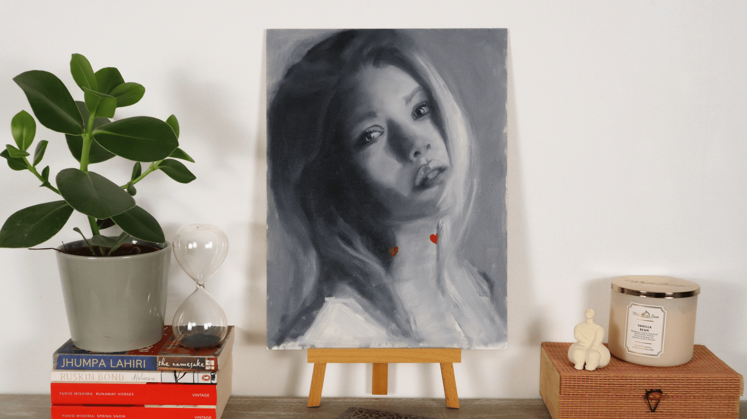 “Crashing Hearts” figurative portrait painting displayed in a modern interior, featuring a grayscale female figure with red heart details.
