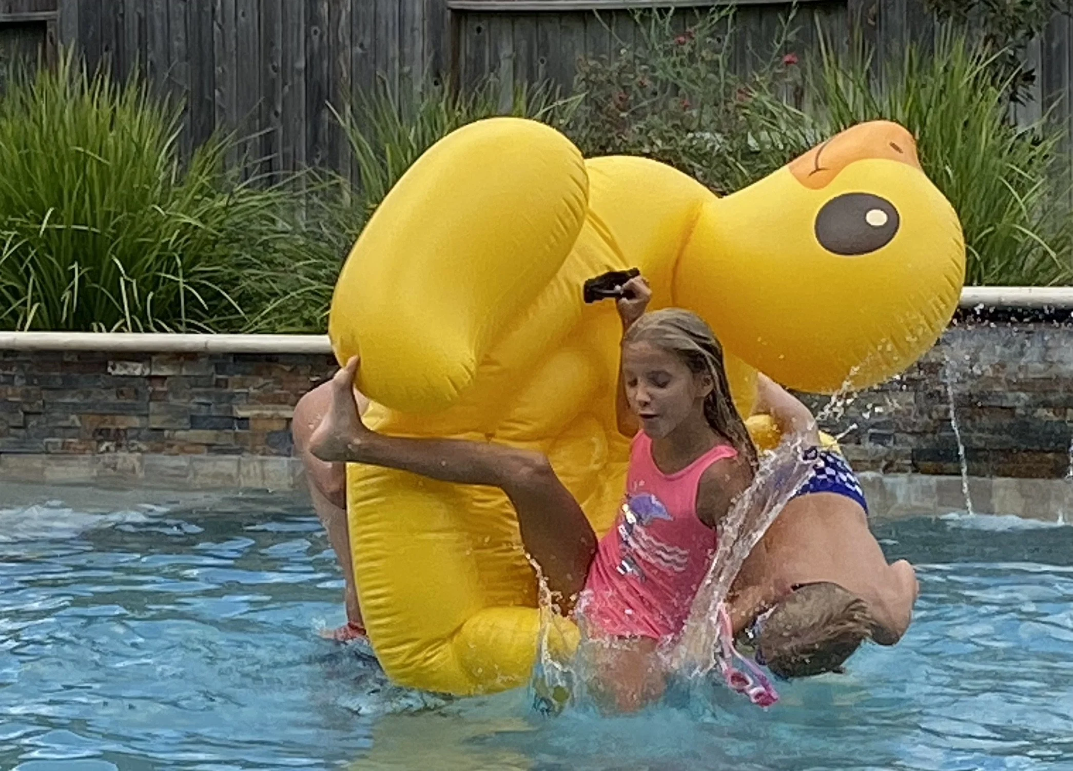 Happy customers in Bridgeland swimming in pool by Texas Custom Outdoors