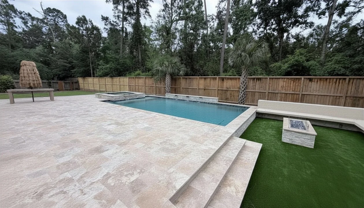 Backyard with a swimming pool, palm trees, a wooden fence, artificial grass, a fire pit, and outdoor seating.