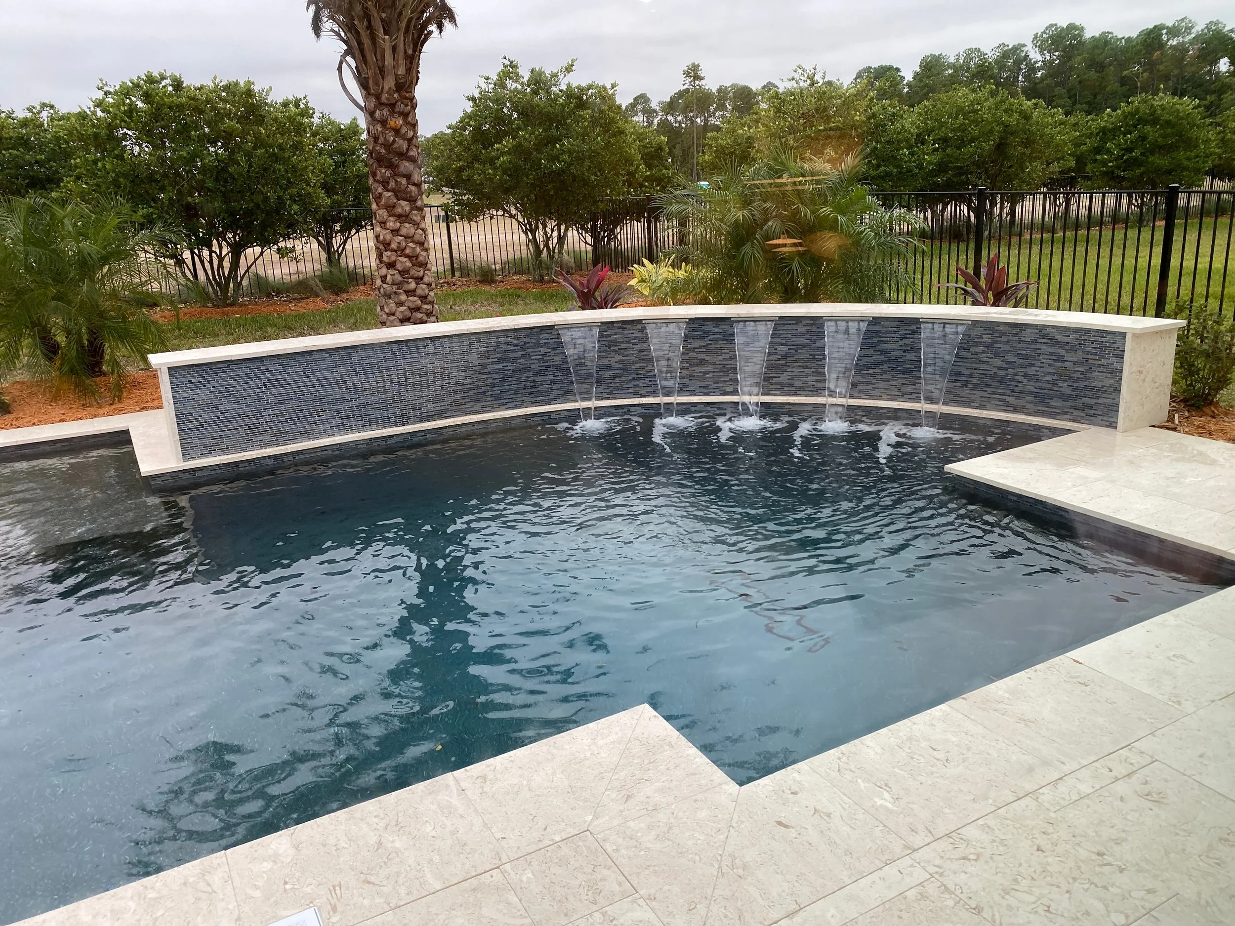 Water feature wall with tile and travertine in Bridgeland community in Cypress, Tx.