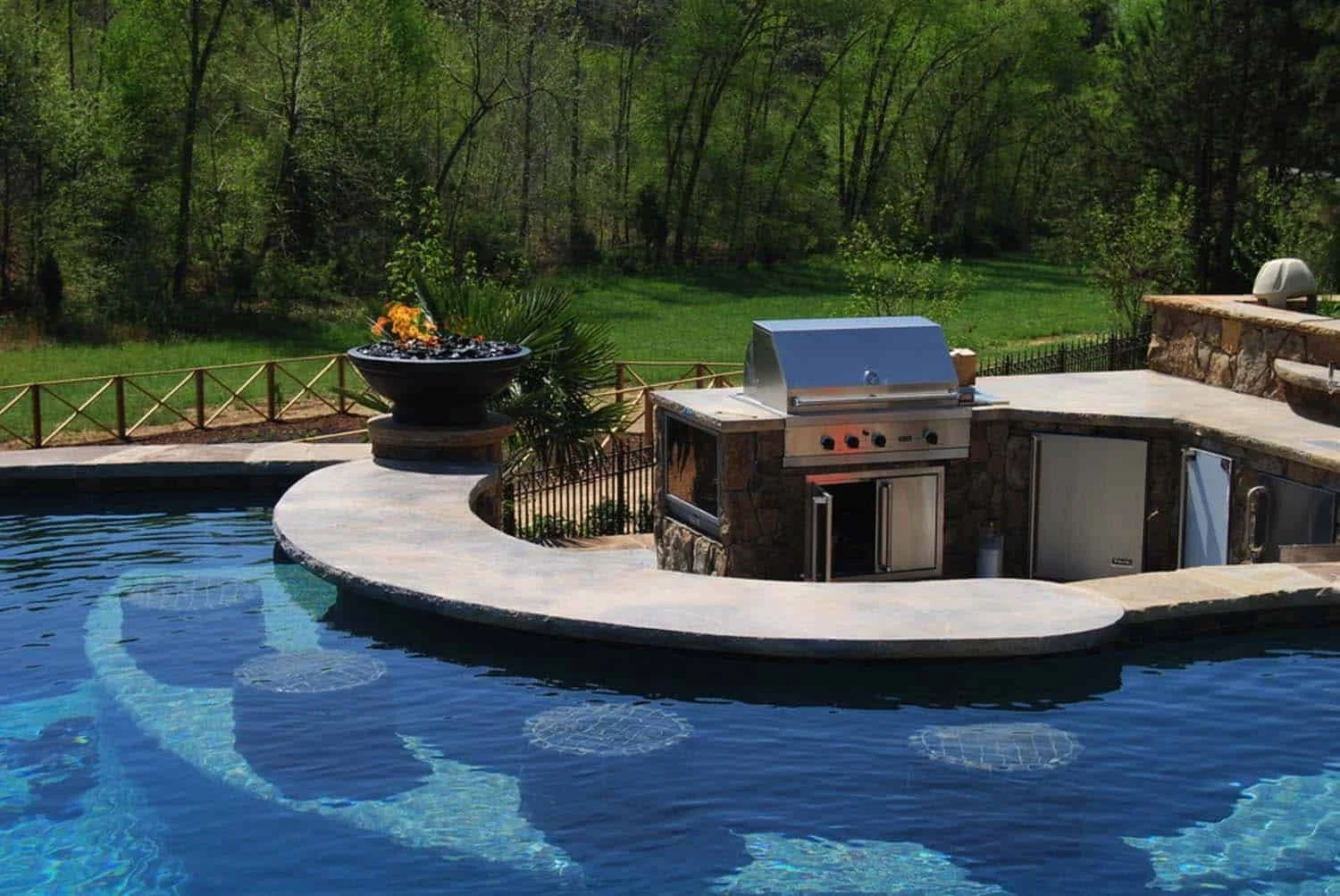 Resort-style swim-up bar and outdoor kitchen perfect for entertaining—custom built for backyard oasis living in Sugar Land, TX