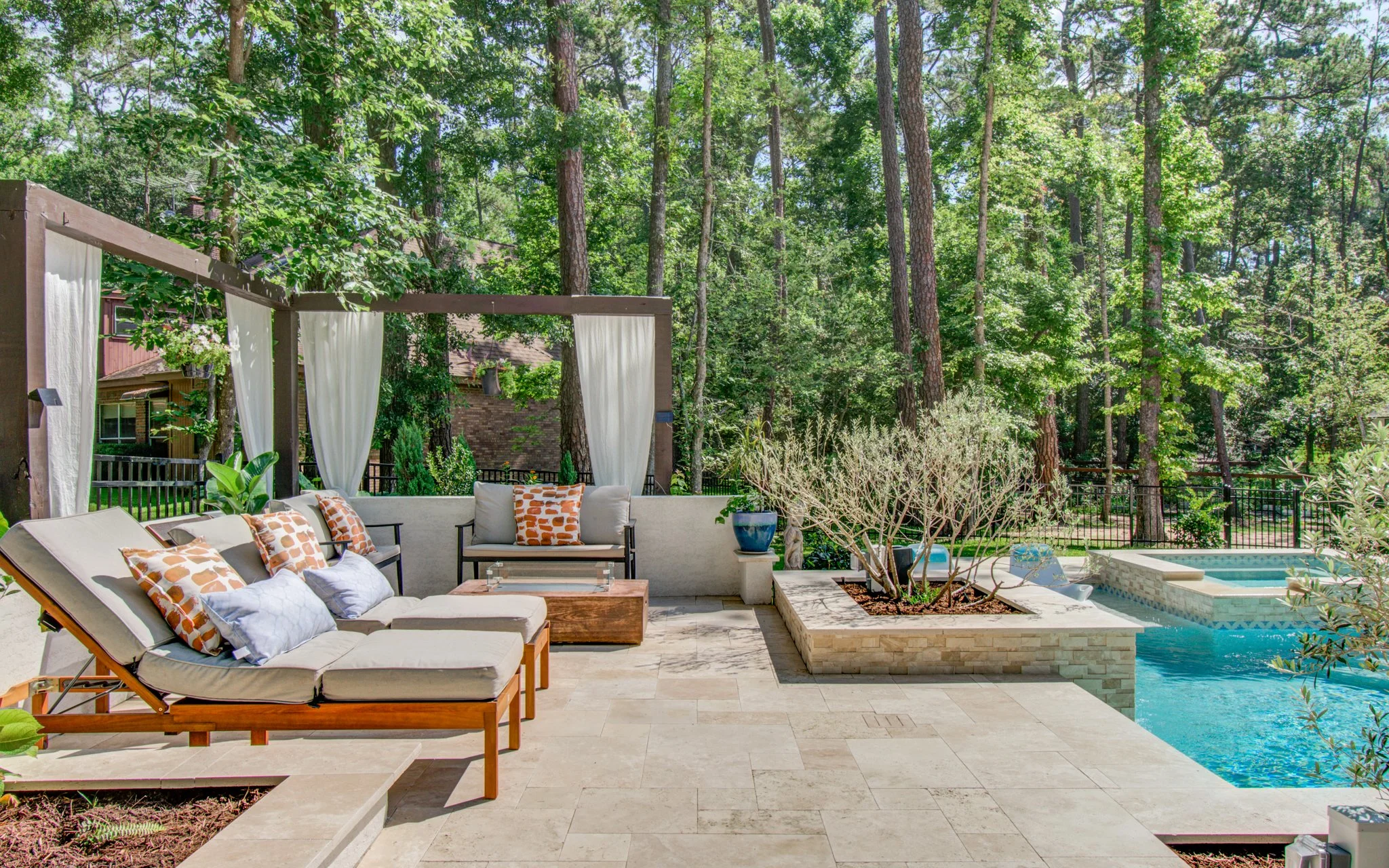 Fire pit lounge area set on ivory travertine beside the pool deck