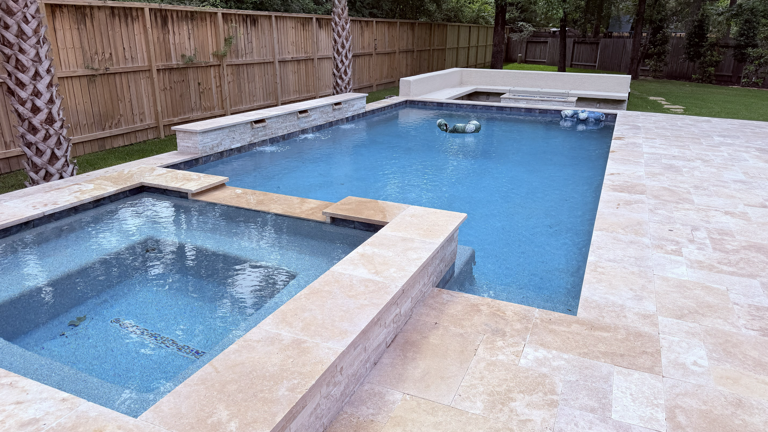 Walnut travertine coping on a Brilliant Blue pool in The Woodlands, TX